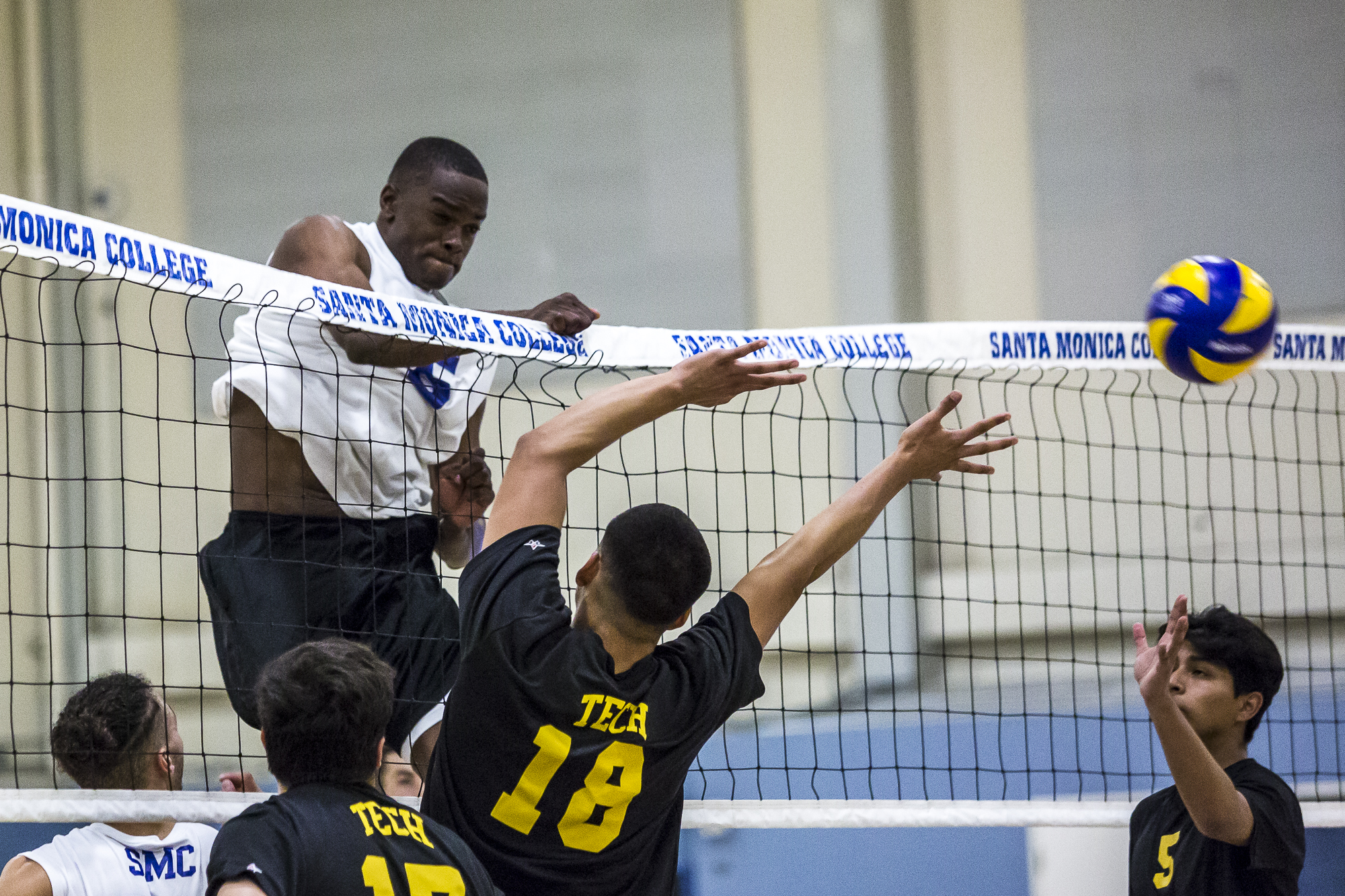  Santa Monica College Corsair middle-hitter Vecas Lewin #15 (left, white) nails a very powerful spike into the Los Angeles Trade Tech Beaver defense during the Corsairs 3-0 blowout victory against the Tech Beavers in the Santa Monica College (SMC) Pa