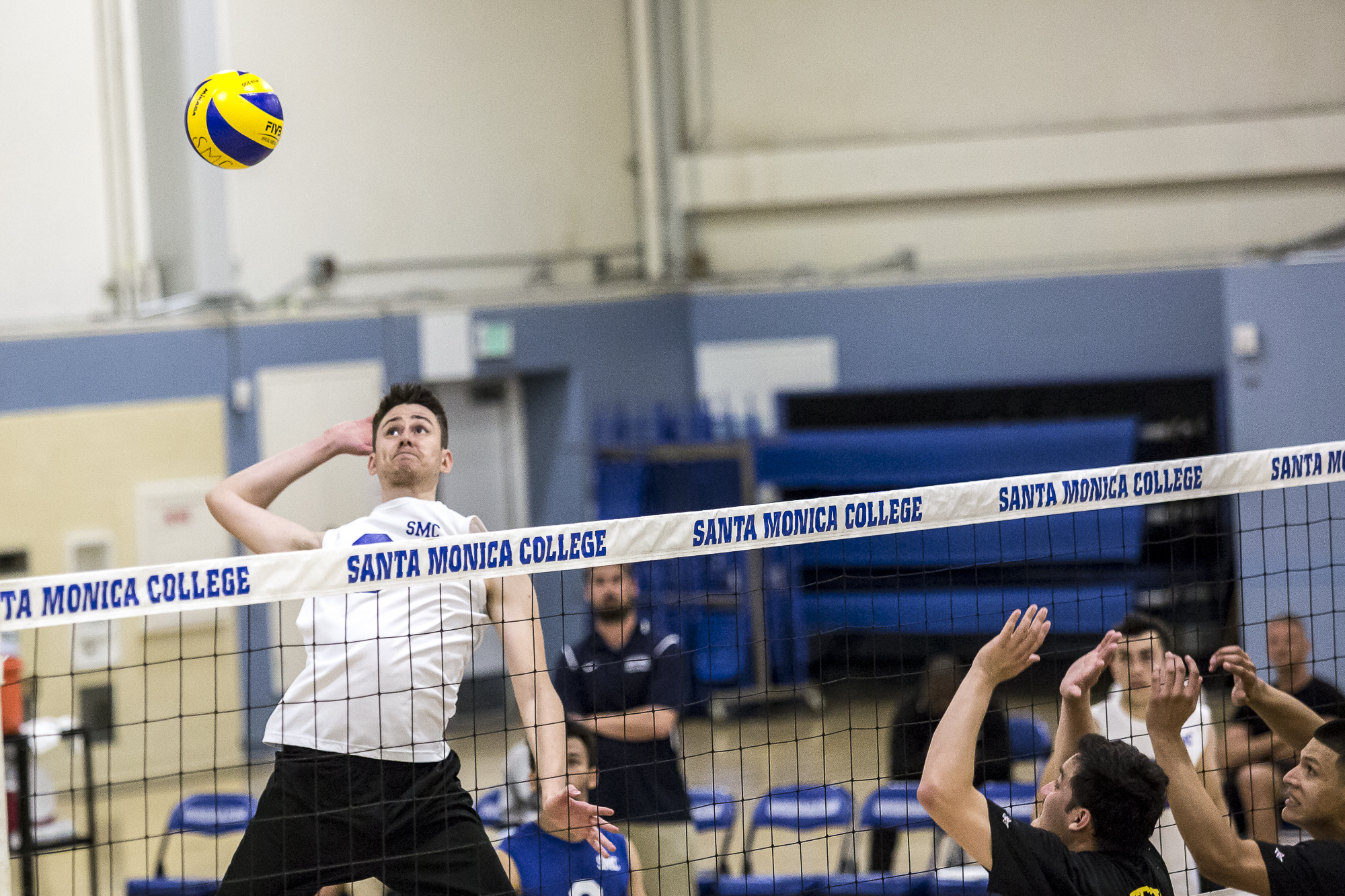  Santa Monica College Corsair middle-hitter Nick Kostetsky #8 (left, white) leaps in the air to hit a very powerful spike into the defense of the Los Angeles Trade Tech Beavers during the Corsairs 3-0 blowout victory against the Tech Beavers in the S