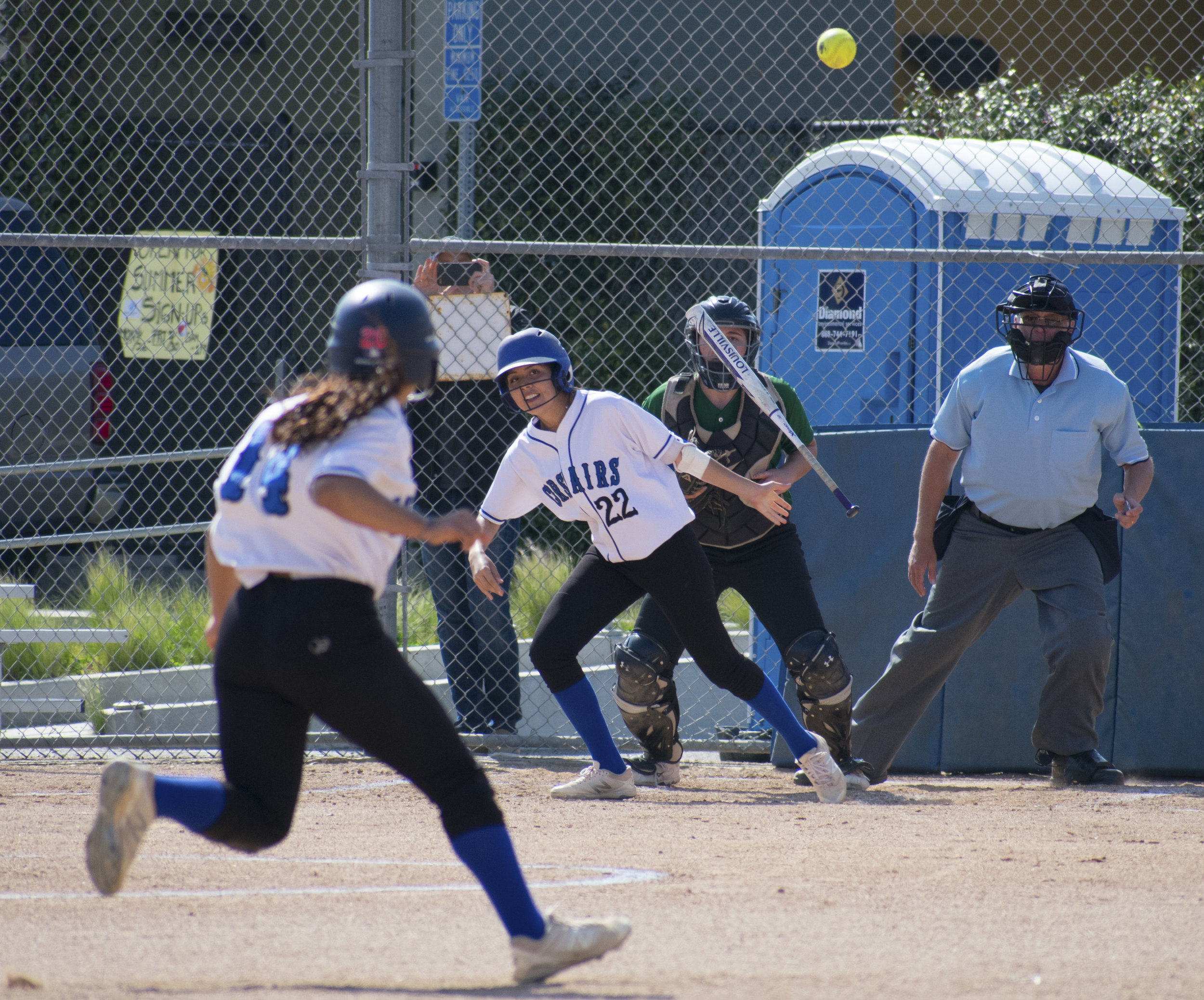 Santa Monica Corsair Erika Soto (#22) proceeds to run to second base after striking as Jen Baca (#14) runs to third during a softball game against the Cuesta College Cougars on Tuesday, April 4 at the John Adams Middle School Field in Santa Monica, California. It was a close 10-inning game, which ended in a 6-5 loss for the Corsairs. (Ethan Lauren/Corsair Photo)