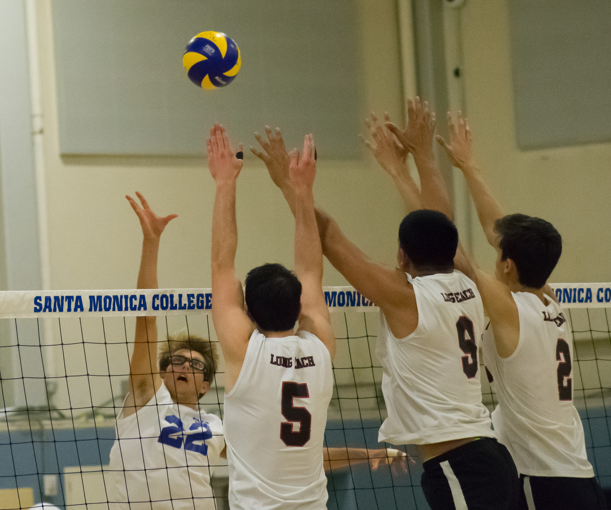 Santa Monica Corsairs sophomore and outside hitter Stanton Smith (#22) attempts to defend against the Long Beach City College Vikings during their final home game of the season on Wednesday, April 12, 2018 in the Santa Monica College gym at Santa Monica, California. The game ended in a 3-1 loss for the Corsairs, giving them a 7-7 overall rating for the season with one game left. (Ethan Lauren/Corsair Photo)