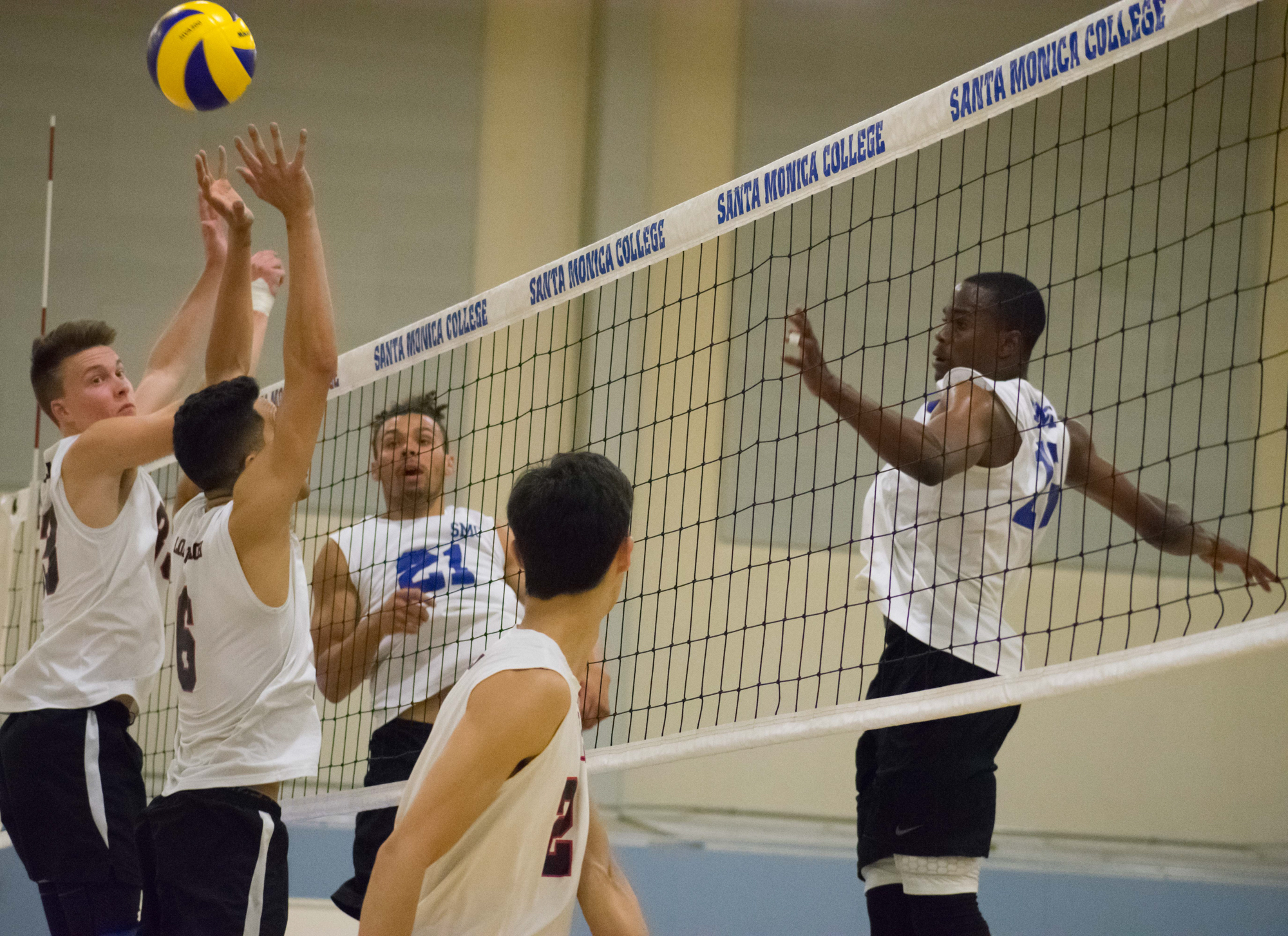 Santa Monica Corsairs sophomores Hunter Douglas (#21), left, and middle hitter Vecas Lewin (#15), right watch the Long Beach City College Vikings attempt to defend during their final home game of the season on Wednesday, April 12, 2018 in the Santa Monica College gym at Santa Monica, California. The game ended in a 3-1 loss for the Corsairs, giving them a 7-7 overall rating for the season with one game left. (Ethan Lauren/Corsair Photo)