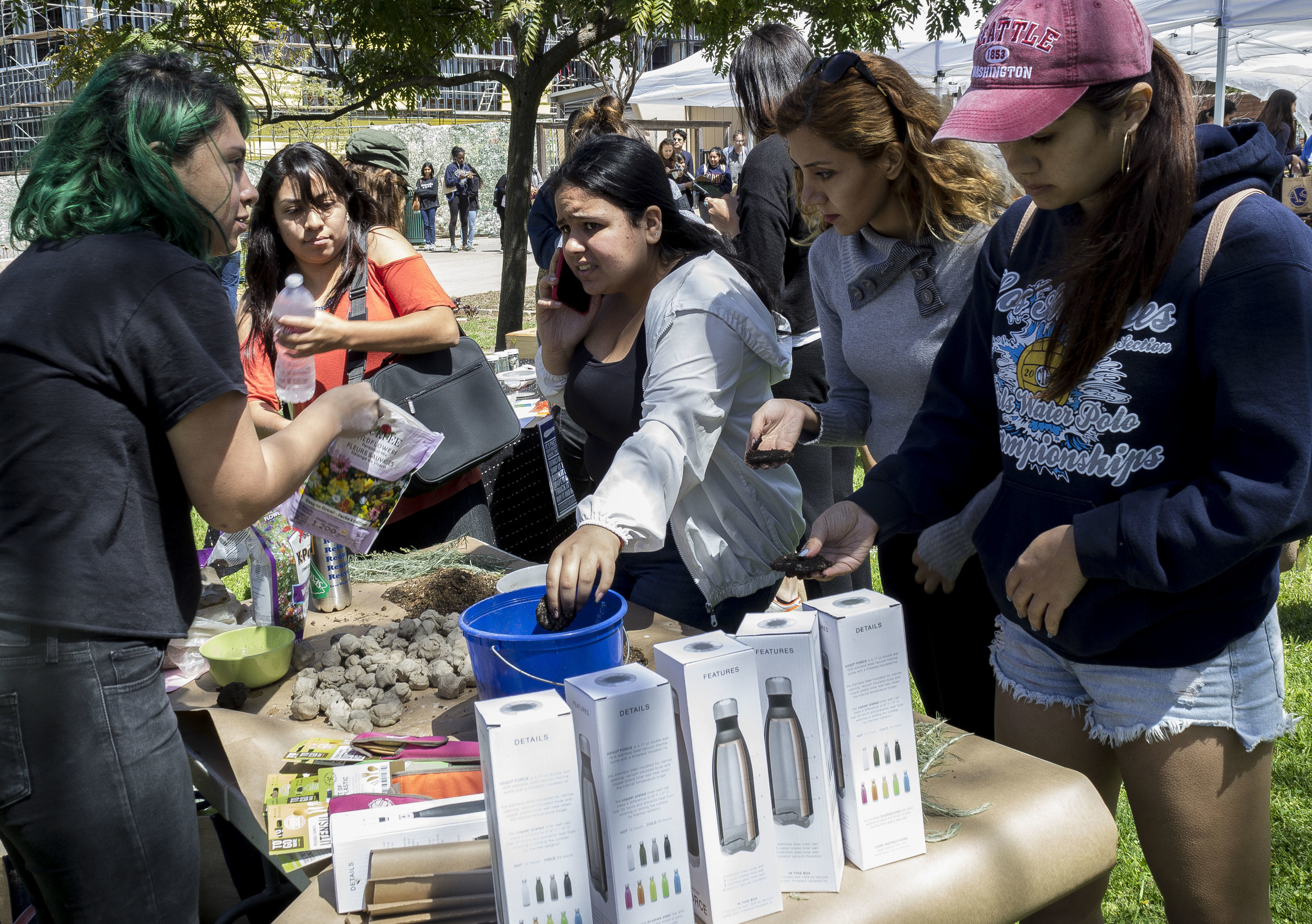 Seed Bombs stand, held by Alexa Benavente (left), freshly elected AS board member for Student Advocacy. Benavente teaches students to make mud balls to plant seeds. Earth Week started with 'Students Feeding Students' Free Farmers Market & Food Demos on Monday, April 16, 2018. At Santa Monica College, Santa Monica California. (Emeline Moquillon/Corsair Photo)
