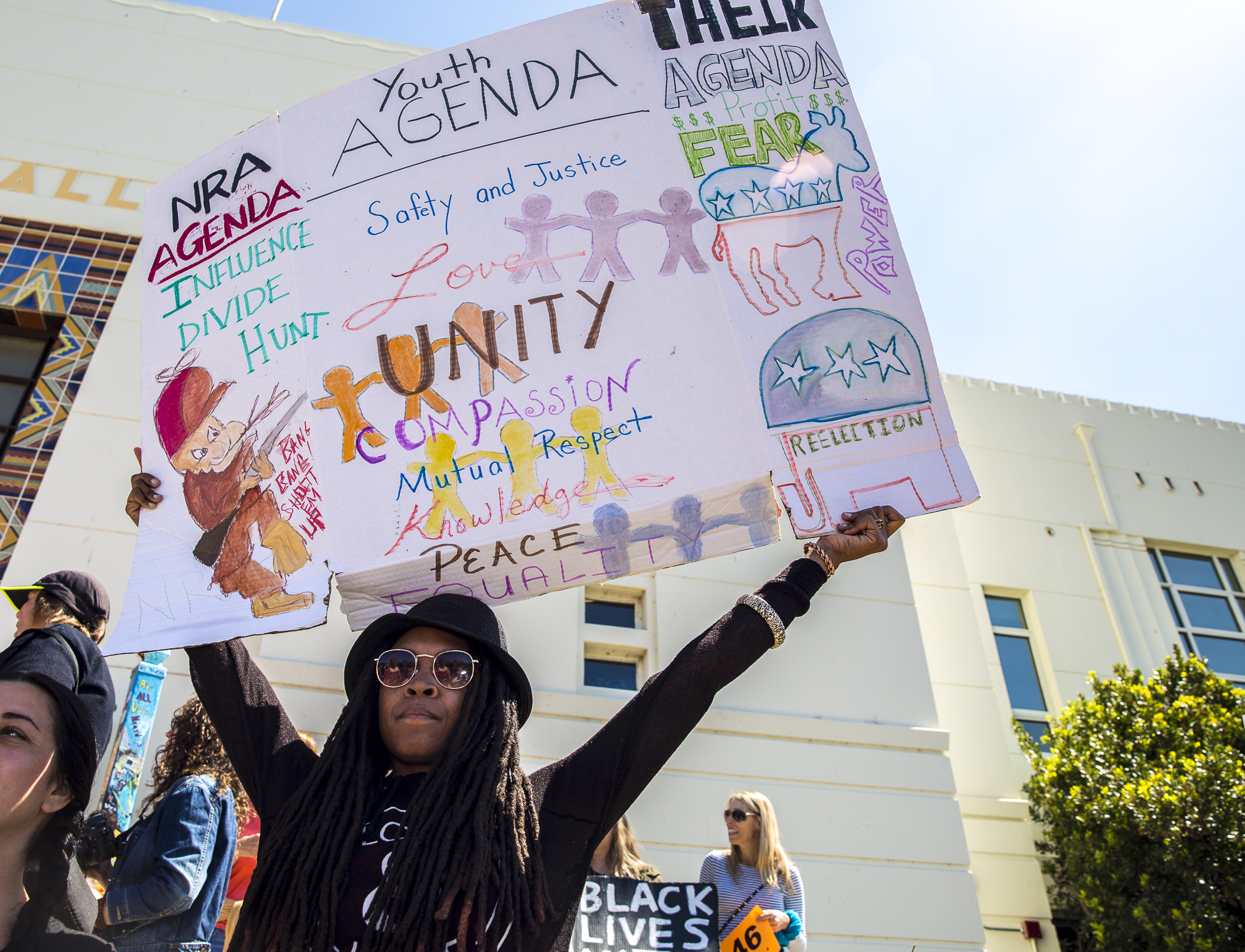  Felecia Lenee, better known as “Fe Love” to her fans, holds up a sign that describes unity, respect, and love during the Santa Monica student walkout where students of neighboring high schools and middle schools converged at Santa Monica City Hall i