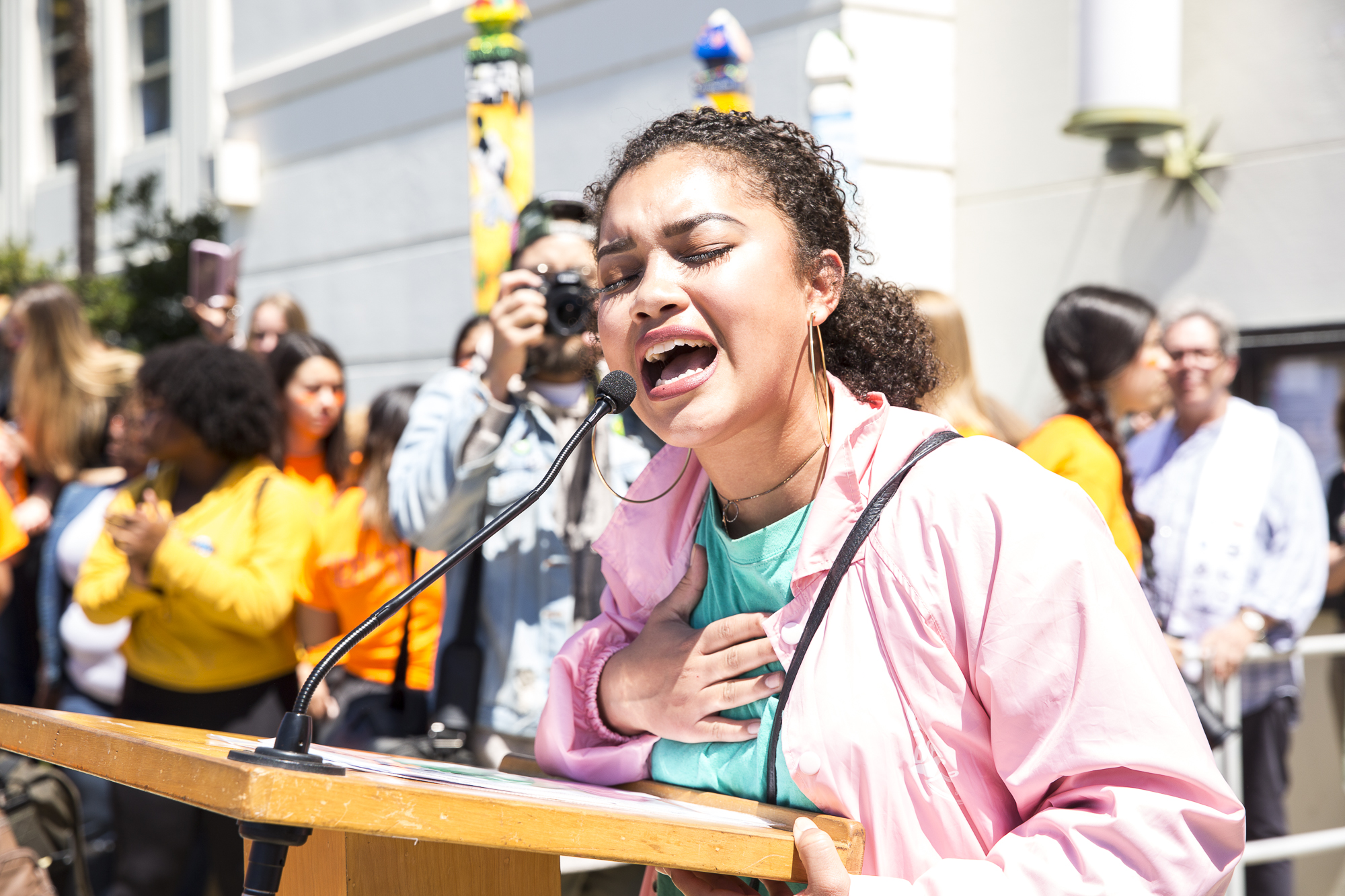  Flora Chavez (21), one of the key speakers during the student walkout that converged at Santa Monica City Hall sings a song she wrote entitled, “Peace Love Unity” to those in attendance in Santa Monica California, on Friday, April 20 2018. Several h