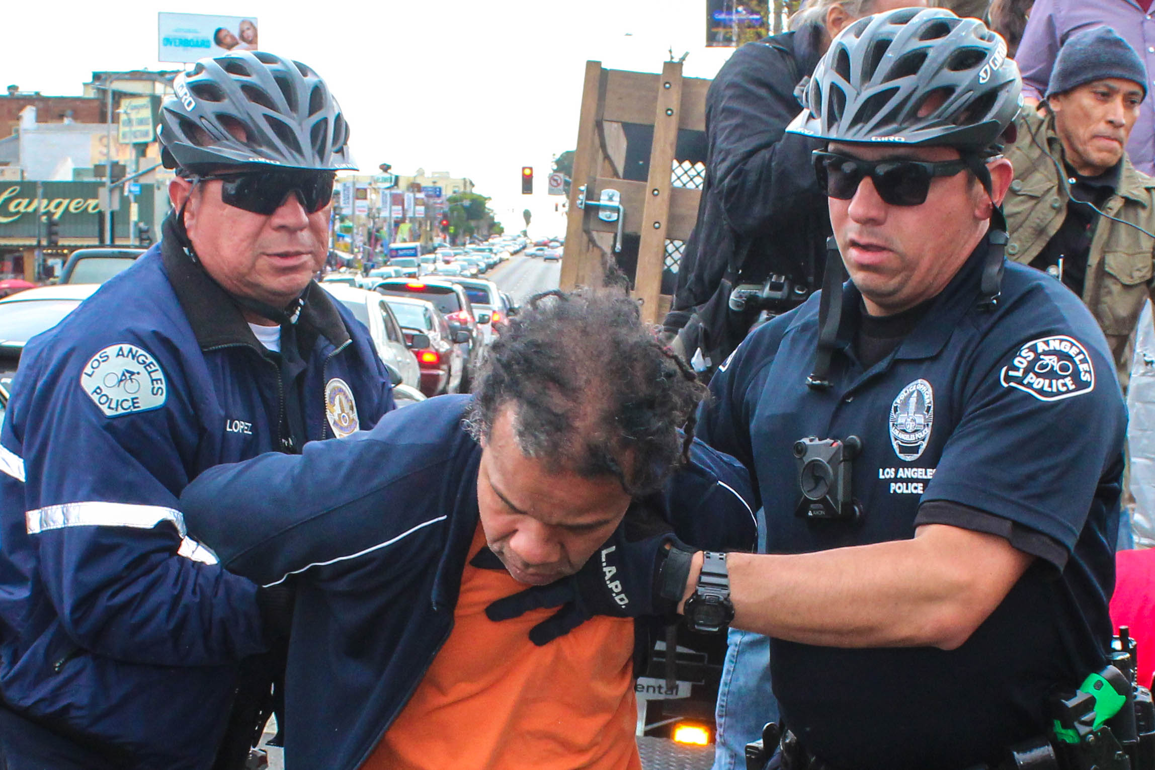 Police detain Washington Azeveel at the May Day Protest in Downtown Los Angeles on May 1, 2018, because two event attendees began pushing each other. (Daniel Farr/Corsair Photo)