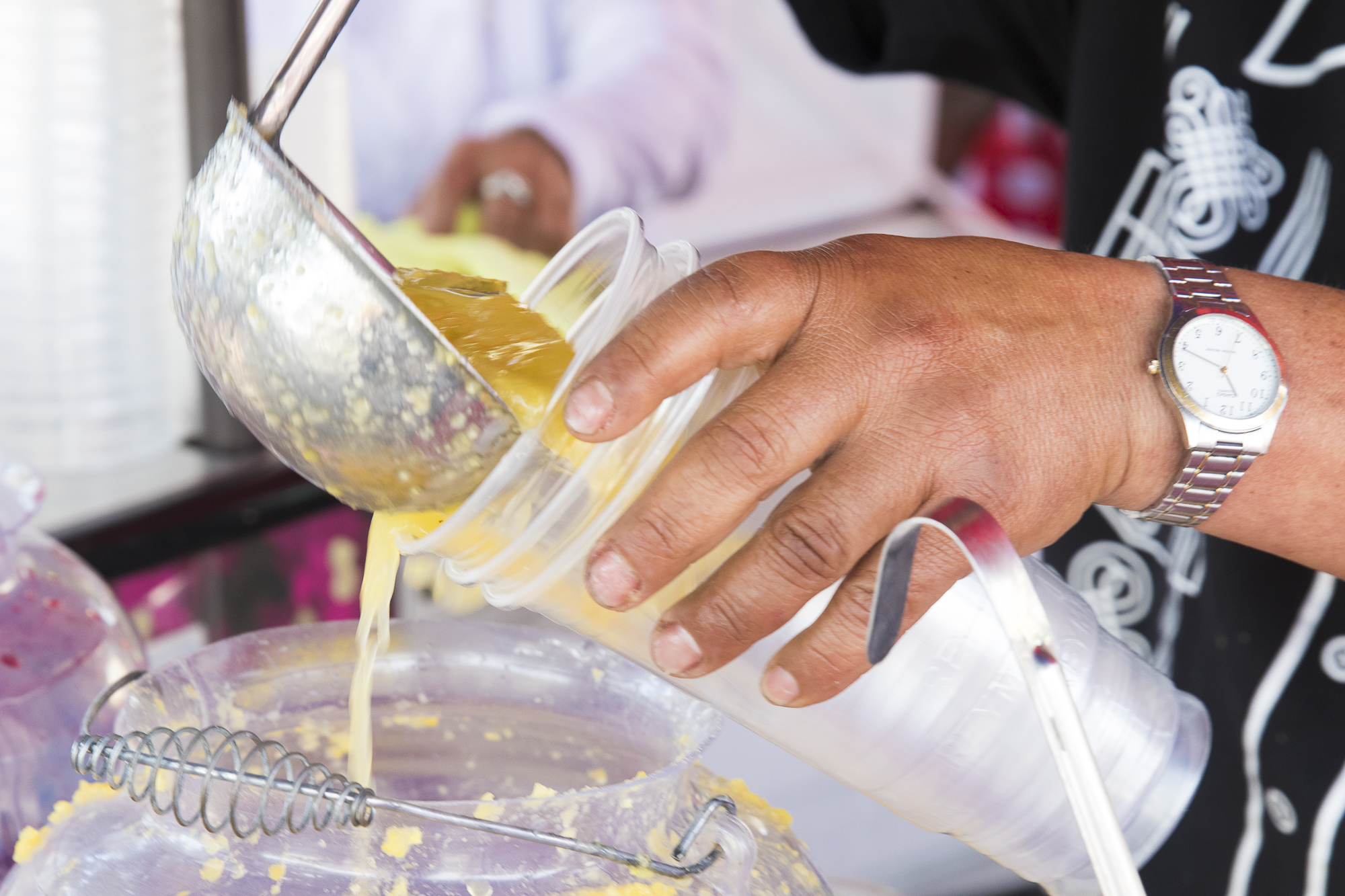 One of the many street vendors on Olvera Street for Cinco De Mayo 2018 pours a glass of Agua De Pina for an event attendee on May 5, 2018 in Downtown Los Angeles, California. (Zane Meyer-Thornton/Corsair Photo)