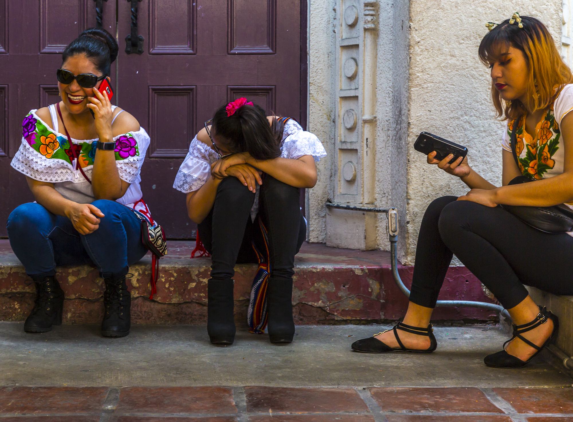 Alejandra Lopez (left) Jessica Martinzez, (middle) and Flora Gutierrez (right) take a break from working one of the many multiple shops set up filled with traditional Mexican products on sale for the people celebrating Cinco De Mayo, which was held at El Pueblo de Los Angeles Historic Monument on Olvera Street on May 5th, 2018 (Matthew Martin/Corsair Photo)
