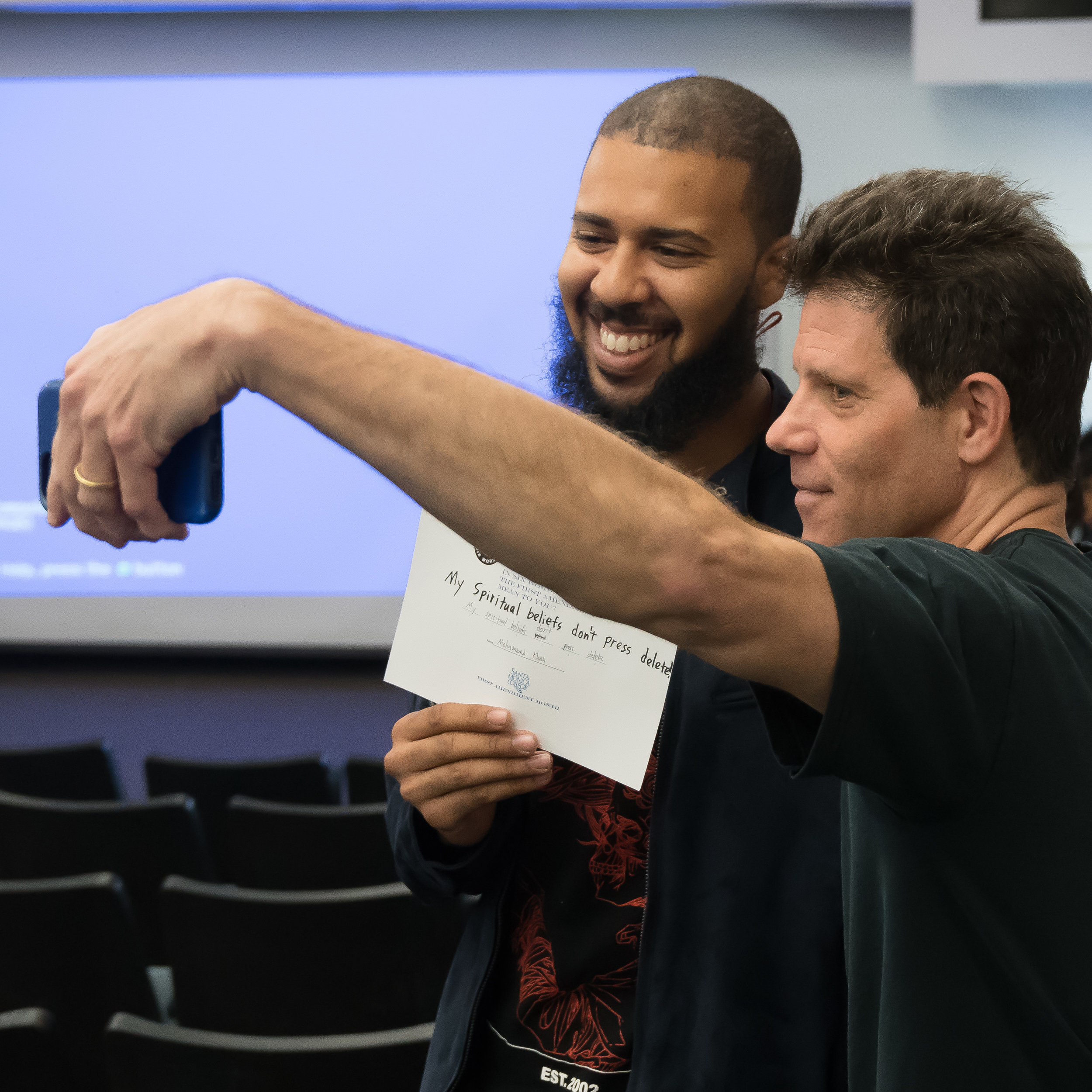  Larry Smith (right) founder of Six-Word Memoirs, takes a selfie with student Mohammed Khan at Santa Monica College in Santa Monica, California on May 3, 2018. Smith spoke about summarizing the meaning of the First Amendment in six words, and was esp