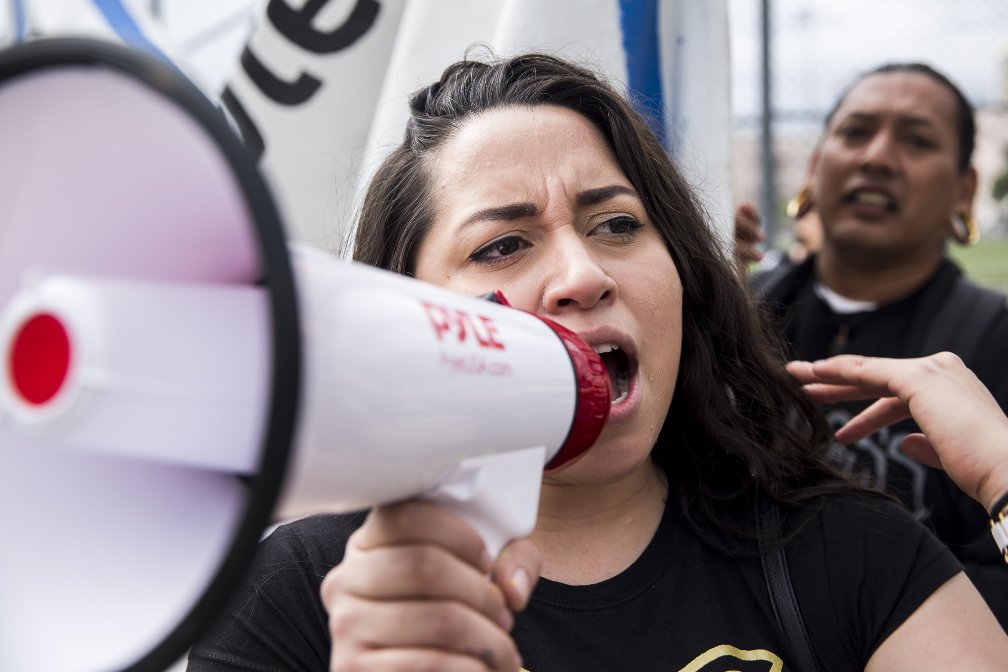  Movimiento Cosecha member and community organizer Claudia Treminio chants and sings into a megaphone while marching down 7th street from MacArther Park during the undocumented immigrant mother’s rally that took place in downtown Los Angeles, Califor