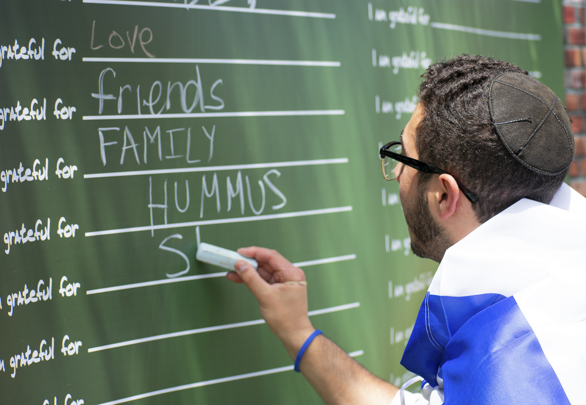  Isaac Shafa, a board member of the Students Supporting Israel club at Santa Monica College is in the midst of writing “shawarma” during an event put on by the club on Thursday, May 10 in Santa Monica, California. The event was a celebration for the 