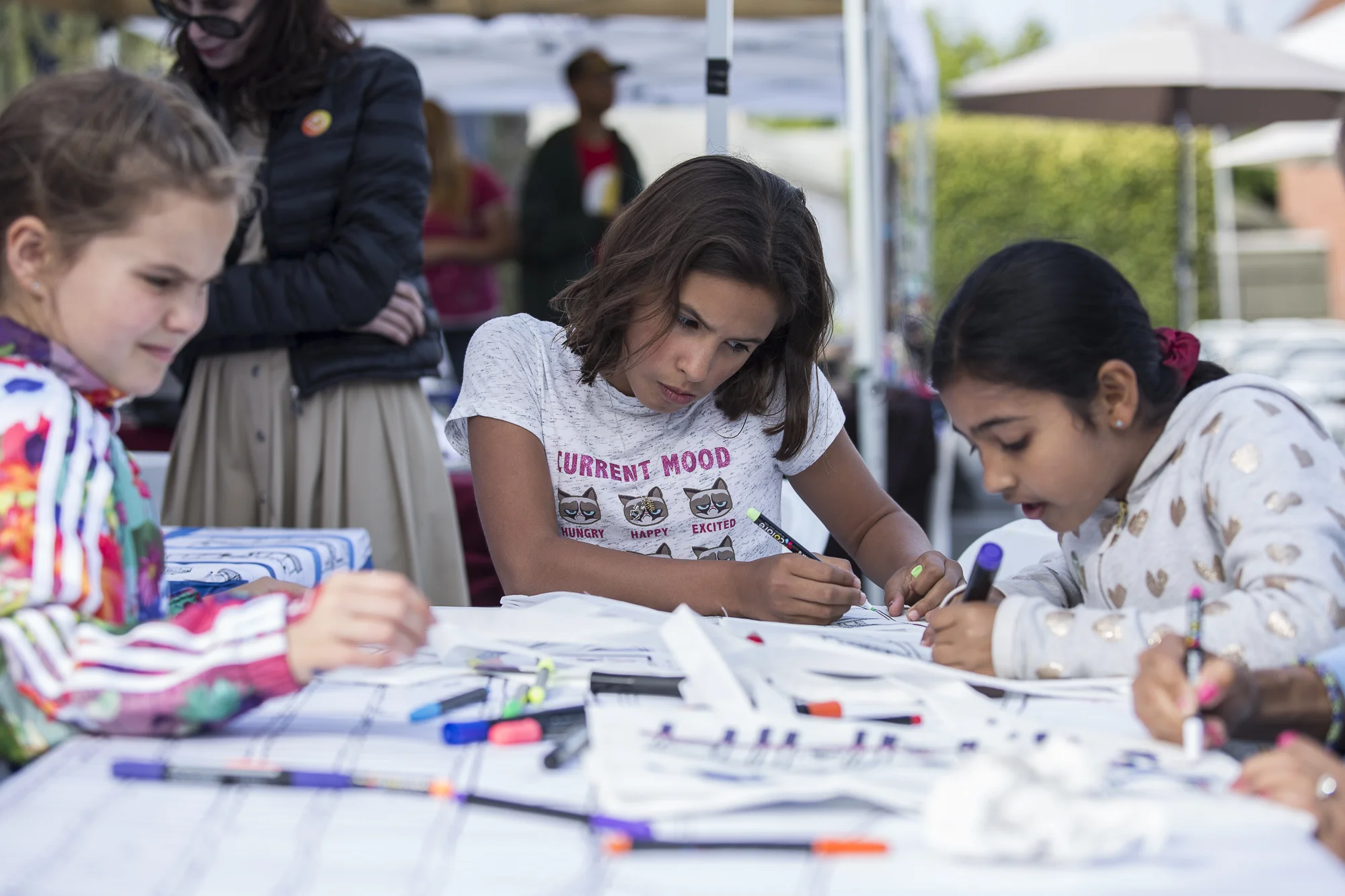 Santa Monica resident Bianka Henry (center) colors in a tote bag with a printed map resembling interesting locations in the Santa Monica area during the Pico Block Party festivities that took place at the 18th street Arts Center in Santa Monica, California on Saturday May 19, 2018. The Pico Block Party is a celebration of artists and cultures of the Pico neighborhood in Santa Monica with the festivities primarily focusing on youth artists and empowering youth voices. (Matthew Martin/Corsair Photo)