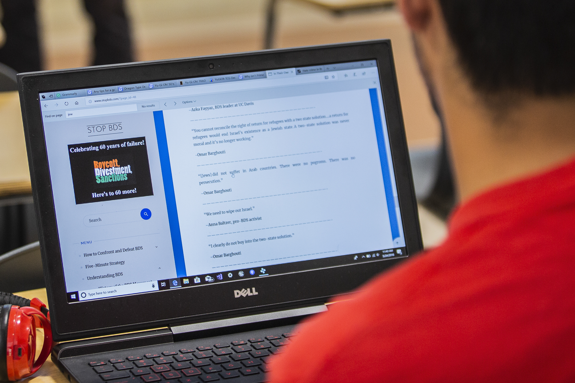 Santa Monica College student Faraz Moallemi divides his attention between a website explaining the Boycott, Divestment and Sanctions Movement (BDS) and the spokesperson for the Students Supporting Israel, Justin Feldman (not pictured) at Santa Monic
