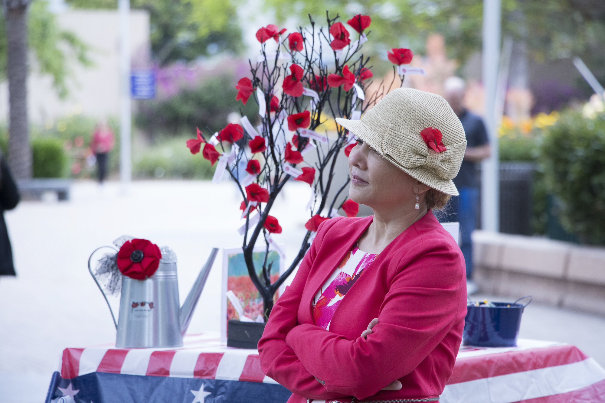 Cynthia Gonzales, a professor at Santa Monica College and a member of the American Legion Auxillary, stood off to the side, in front of a display with red poppys during a speech at the Memorial Day Commemoration on Thursday, May 25 in Santa Monica, California. (Wilson Gomez/Corsair Photo)