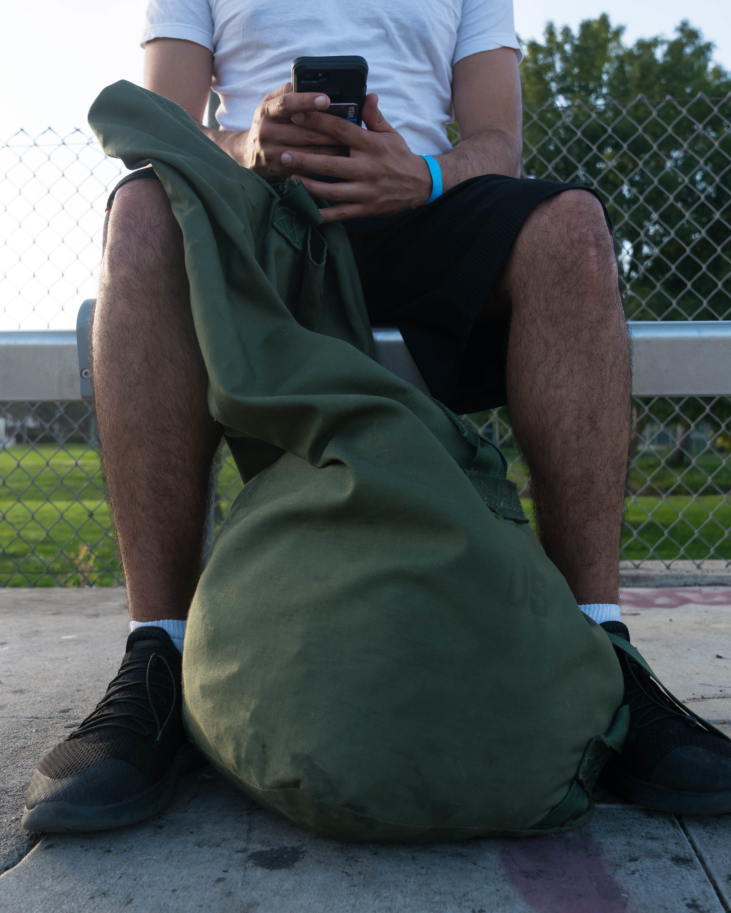 Santa Monica College student, Francisco Munoz, a veteran who experienced homelessness as an SMC student sits with his sea bag stuffed with a backpack, books, a jacket, and towel, at a bus stop in Los Angeles, California on June 3, 2018. Munoz, who cannot afford a car, says he takes the bus everywhere. (Helena Sung/Corsair Photo)