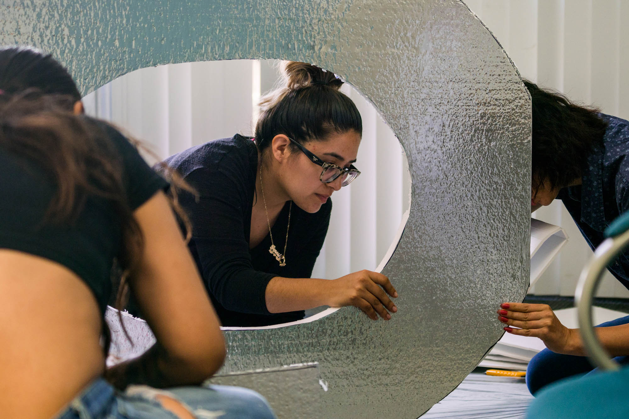 Tracy Hurtado, Genesis Navarro, Naimiyeh Rashidi (from Left to right) from the production team, cut out the letter O. Photo by Rea Sohn/Corsair Contributor
