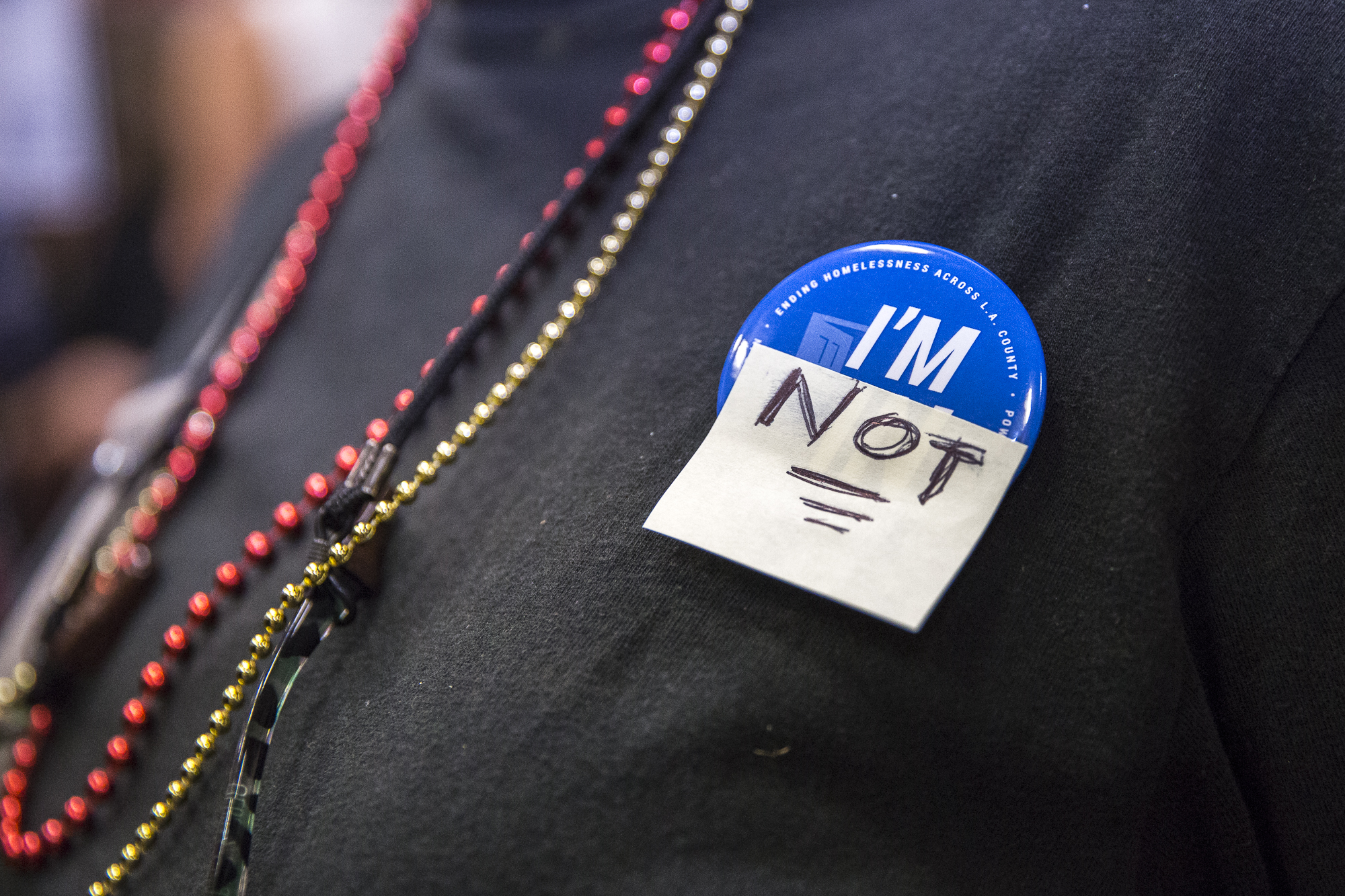  A Venice local who is opposed to the building of a homeless shelter at the former metro bus lot at 100 E. Sunset in Venice that would house 100 people wear a button that reads, “I’m Not” during the town hall at Westminster Elementary School, in Veni