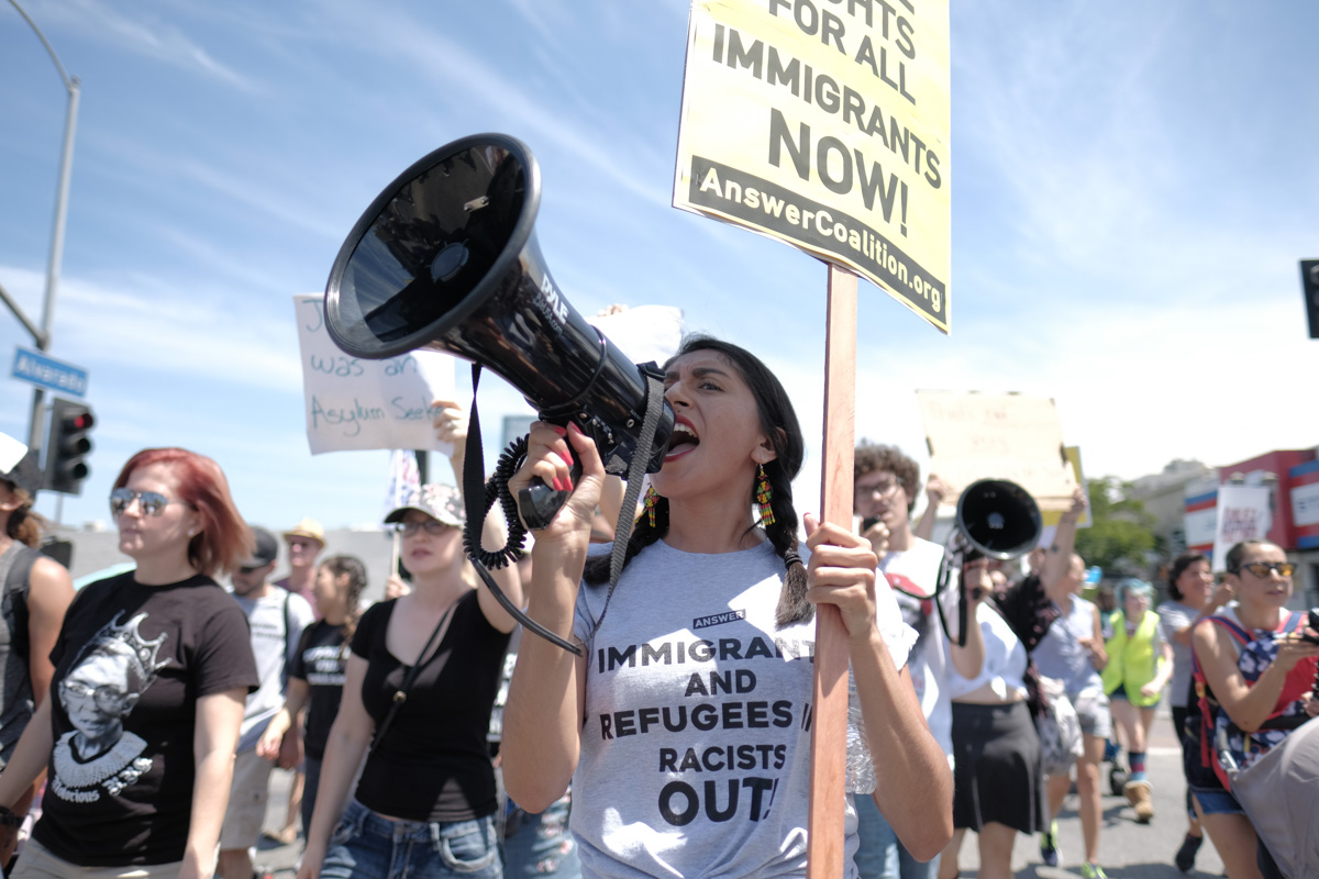 Melina Rodriguez chants into a megaphone during the Families Belong Together March in Los Angeles, CA on July 21, 2018. (Photo by Jayrol San Jose)