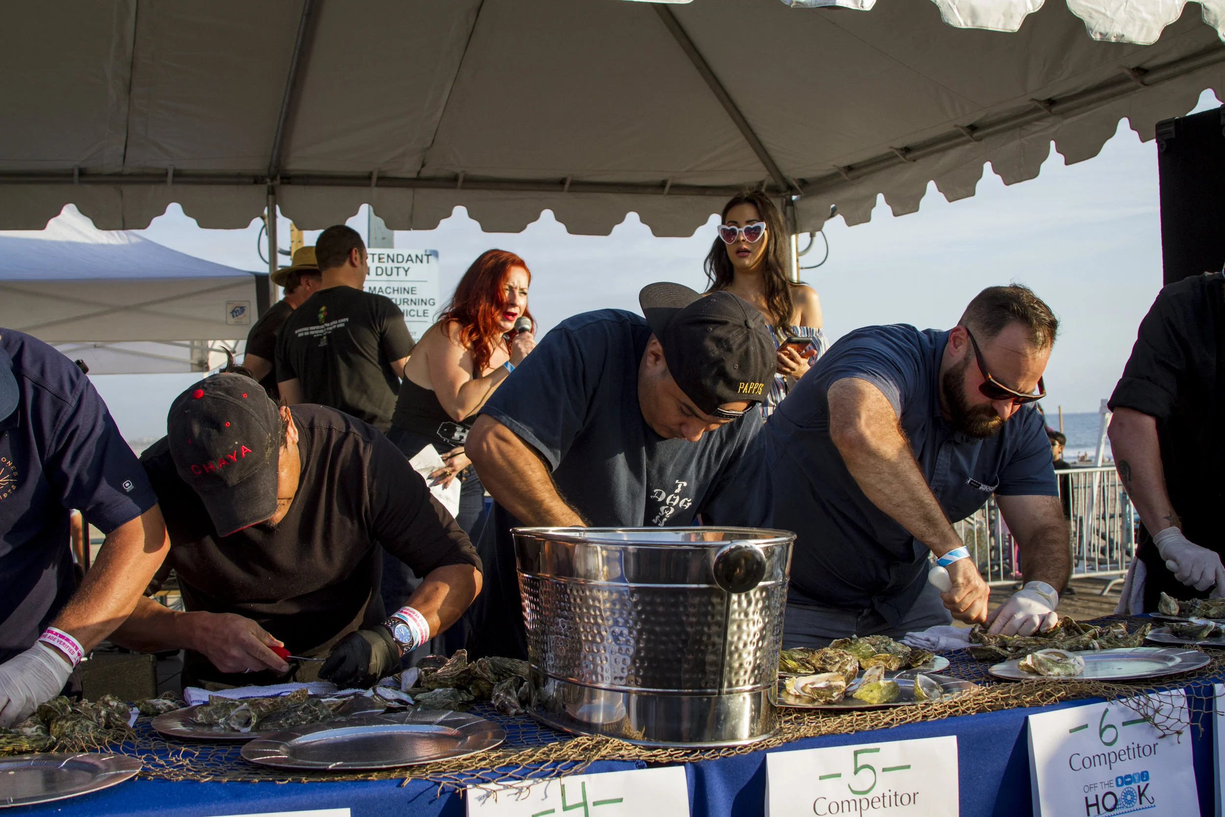 Competitors shucking oysters in under two minutes. At Off the Hook Seafood Festival. Oct. 6, 2018. By Yasser Marte.