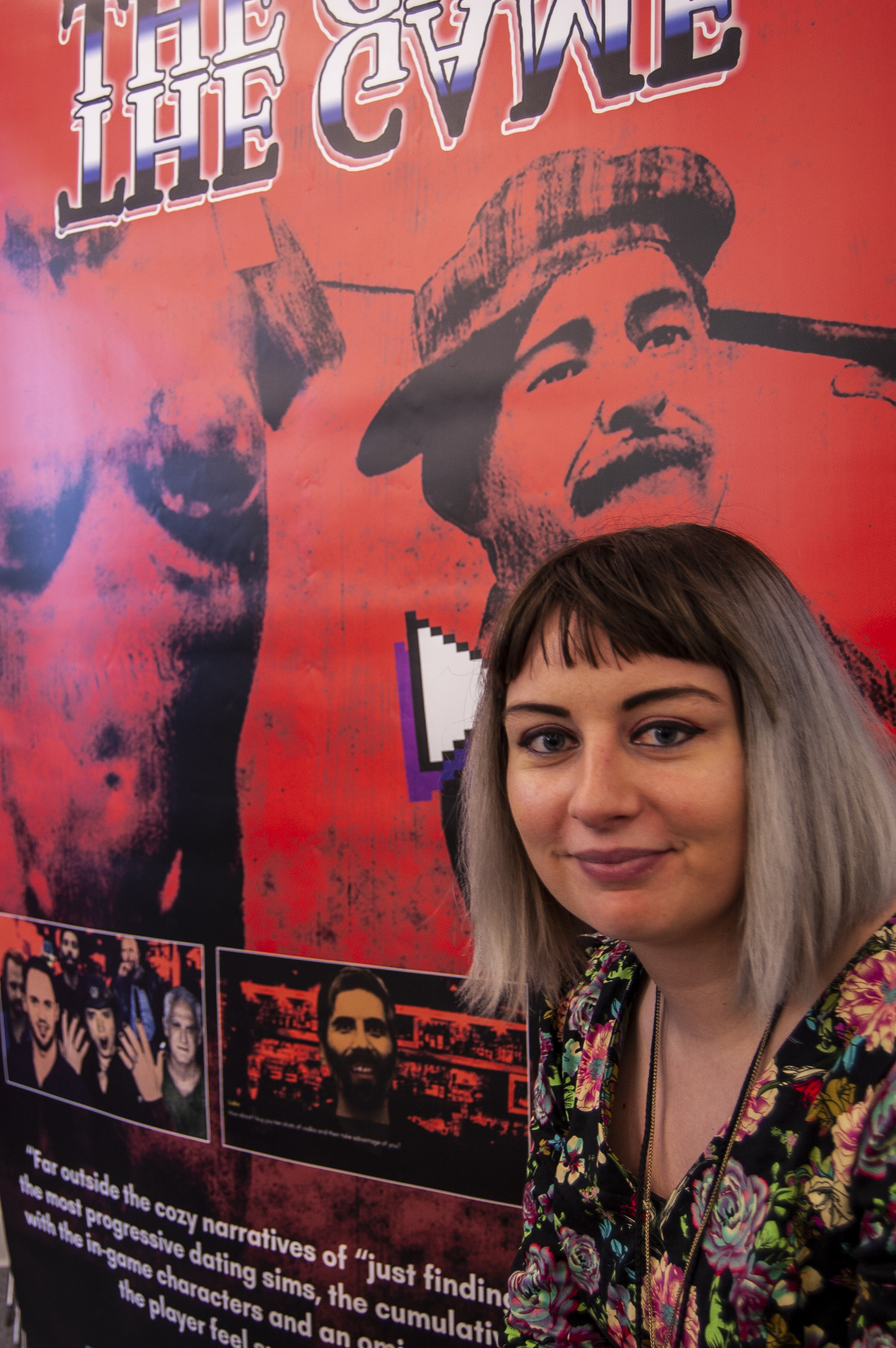 Developer/ designer Angela Washko poses with a poster of her gam