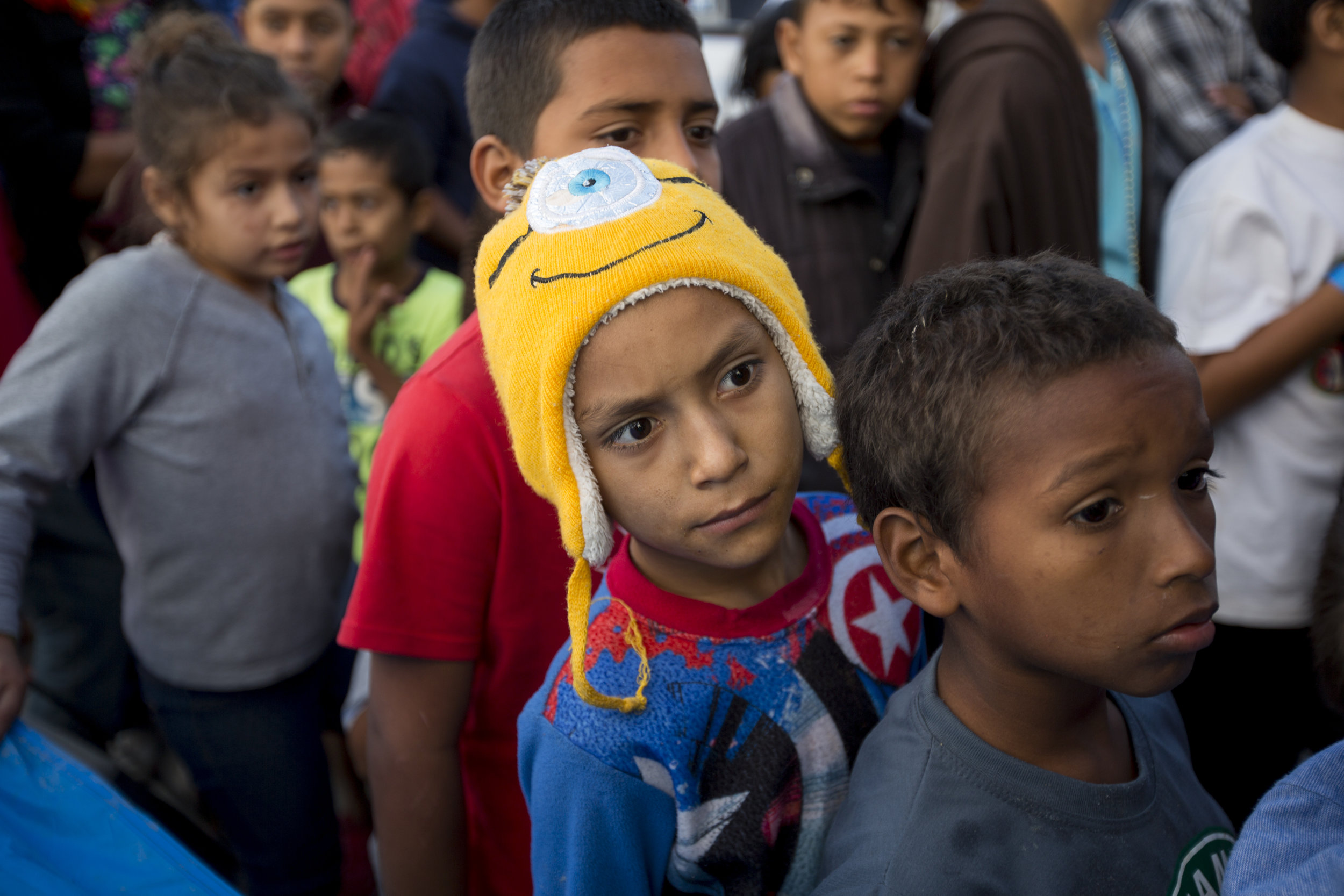   Migrant children line up to receive gifts donated by the local organization Todos Somos Tijuana at the El Barretal shelter on Saturday, Dec. 1, 2018 in Tijuana, Mexico. Photo By: Jose Lopez / Corsair Contributor  