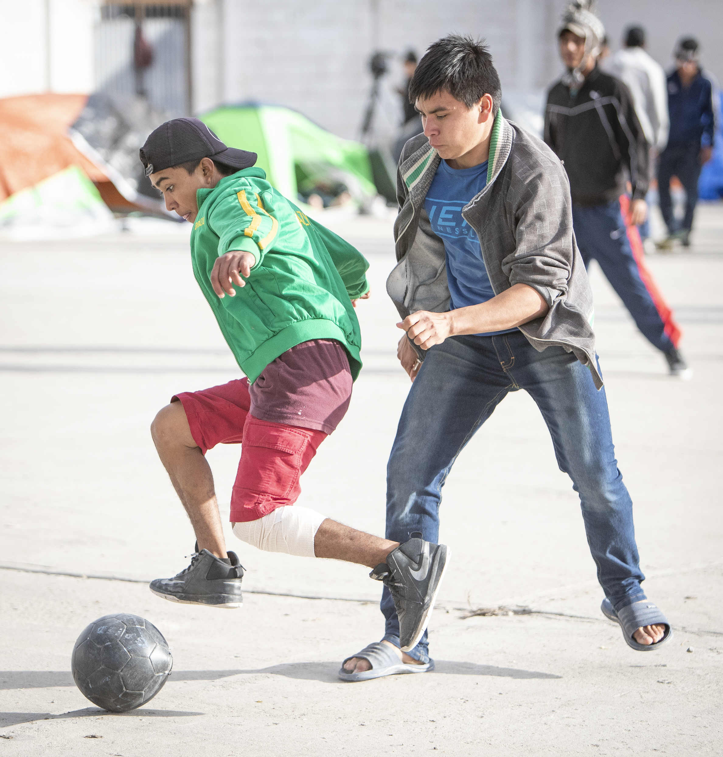   Young male migrant caravan members playing soccer at the El Barretal nightclub turned into a temporary shelter in Tijuana, Mexico, Saturday, Dec. 1, 2018. Photo By: Daniel Bowyer / Corsair Contributor   