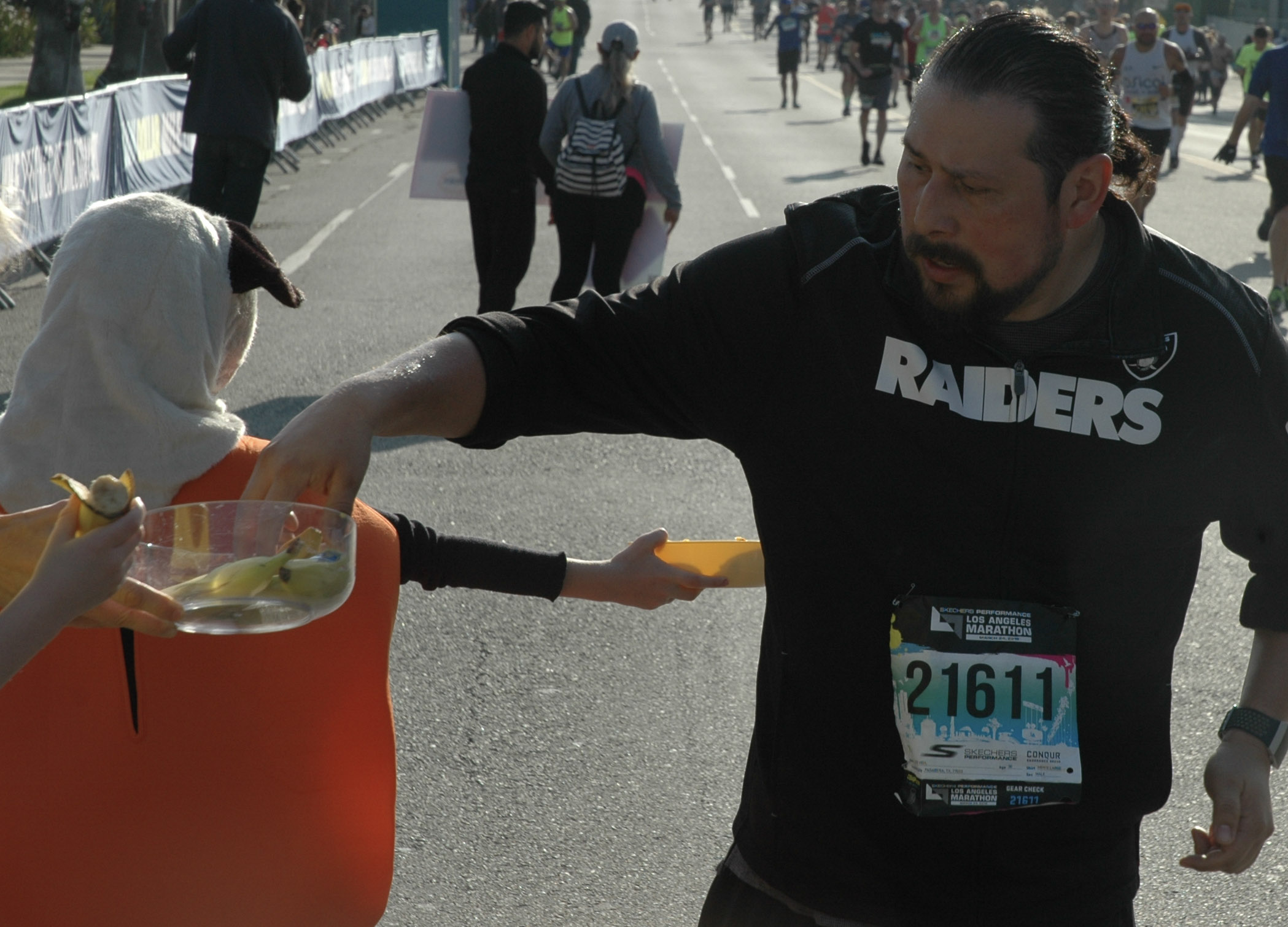  A Los Angeles Marathon runner stops briefly for a banana offered by spectators near the half-way point of the race in Los Angeles, California on March 24, 2019. (Dakota Castets-Didier/The Corsair) 