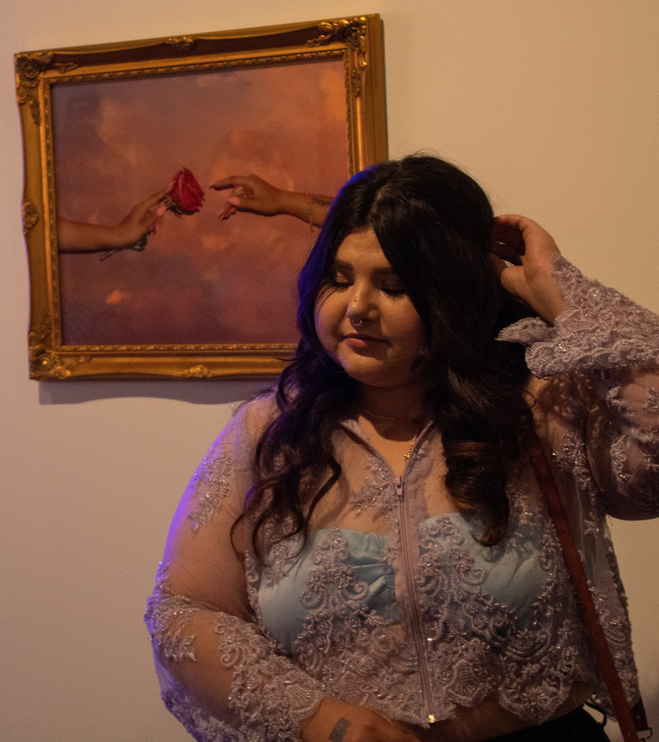  Artist Adriana Serrato in front of her work at We Rise in Los Angeles, California on May 17, 2019. "So pretty much all my pieces are inspired by brown mujeres and cultura and really trying to like represent us because I know in media we aren't reall