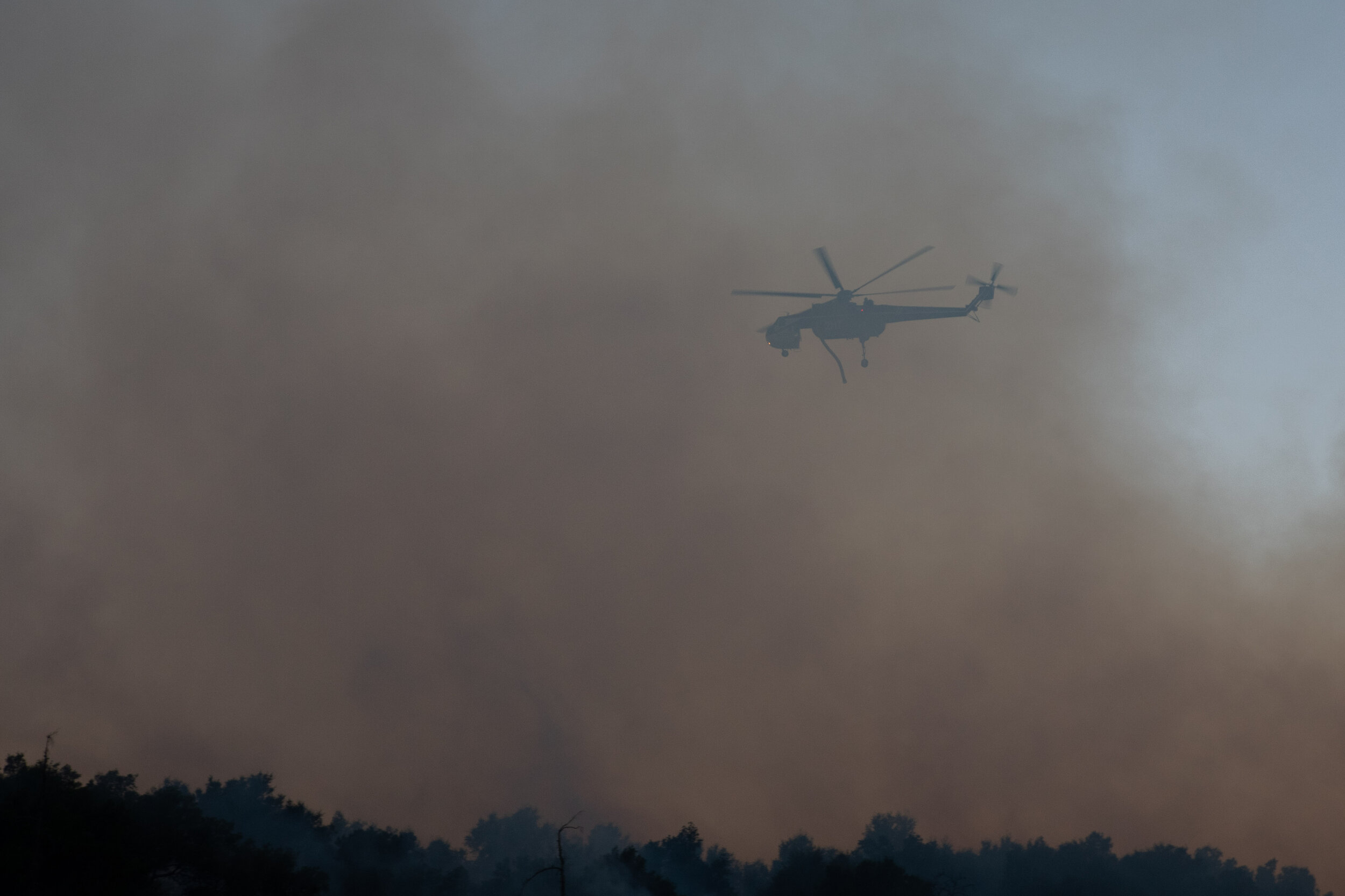  A helitanker behind a cloud of smoke just before it drops water on the Saddlerige Fire just off interstate 5 near Newhall Calif. on Friday, Oct. 11, 2019. (Conner Savage/The Corsair) 