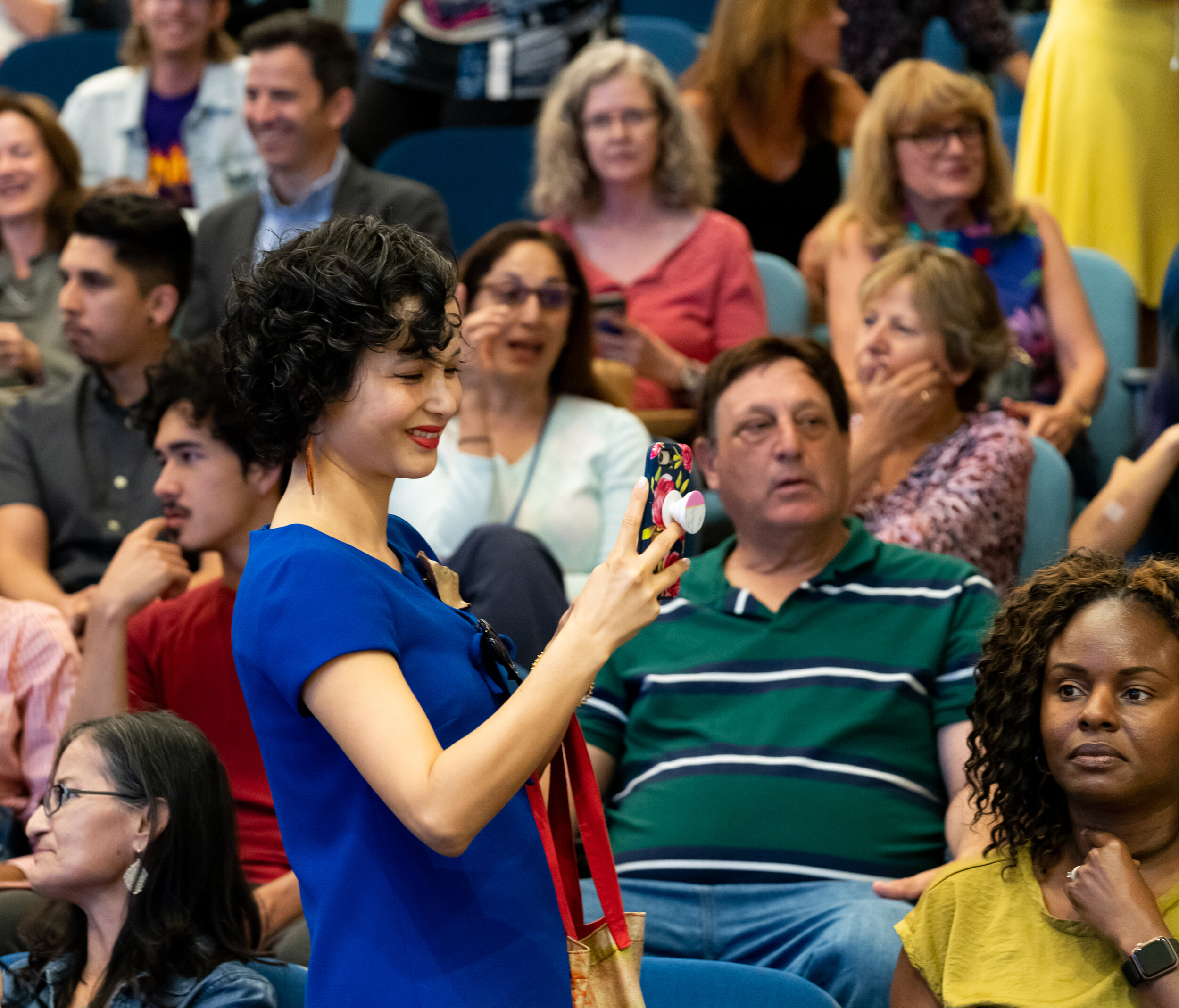  Grace Smith, SMC Public Information Officer, captures images of the crowded auditorium at the at the ribbon cutting ceremony for the new Student Services Center on the Santa Monica College main campus on October 22, 2019. (Suzanne Steiner/The Corsai