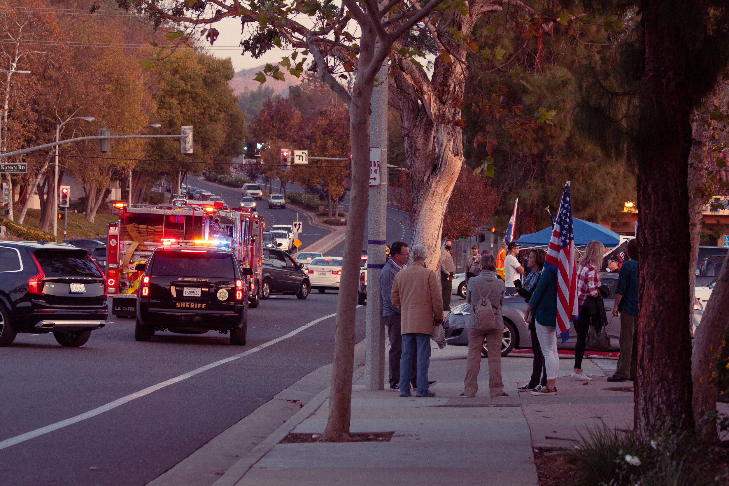  Locals gather outside Cronies Sports Grill to protest the Southern California stay home orders. Police officers and fire fighters from a nearby car accident add to the commotion. Agoura Hills, Calif., on Fri., Dec. 11, 2020. (Johnny Neville / The Co