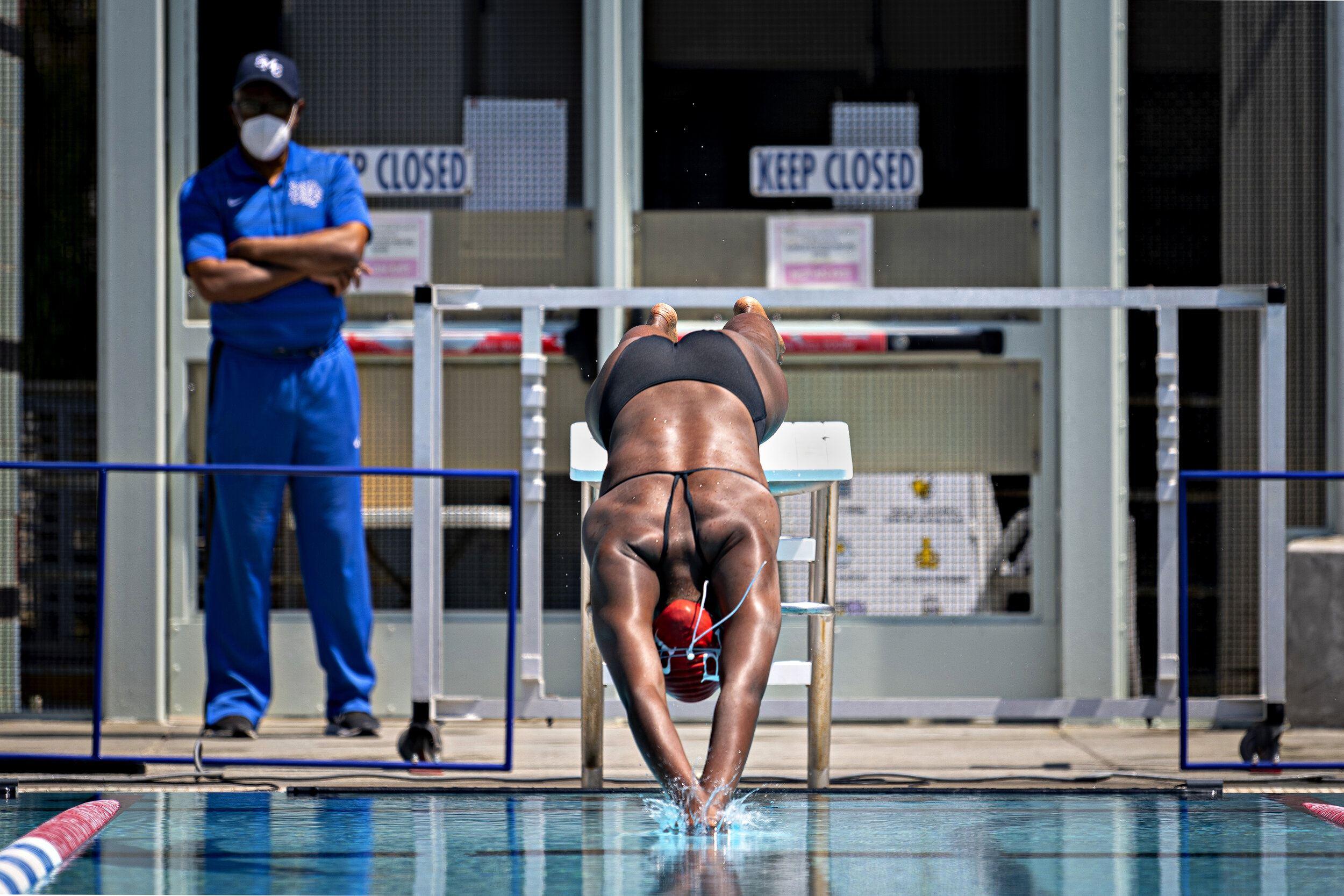  A member of the Bakersfield Women's Swim team breaks the surface of the water in a meet with Santa Monica College on April 16, 2021, in Santa Monica Calif. After being forced to shutdown for nearly a year from the COVID-19 pandemic, the sports progr