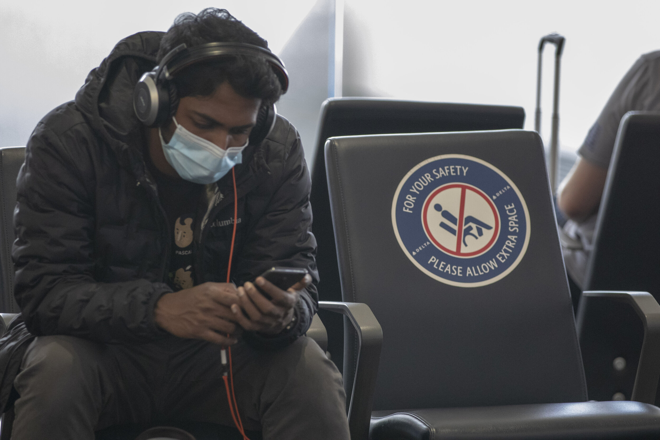  An unknown traveler sits with extra room thanks to a sign that prevents people from sitting next to each other at Los Angeles International Airport Terminal 2 on Thursday 25, 2021 in Los Angeles, Calf. (The Corsair I Brad Wilhite) 