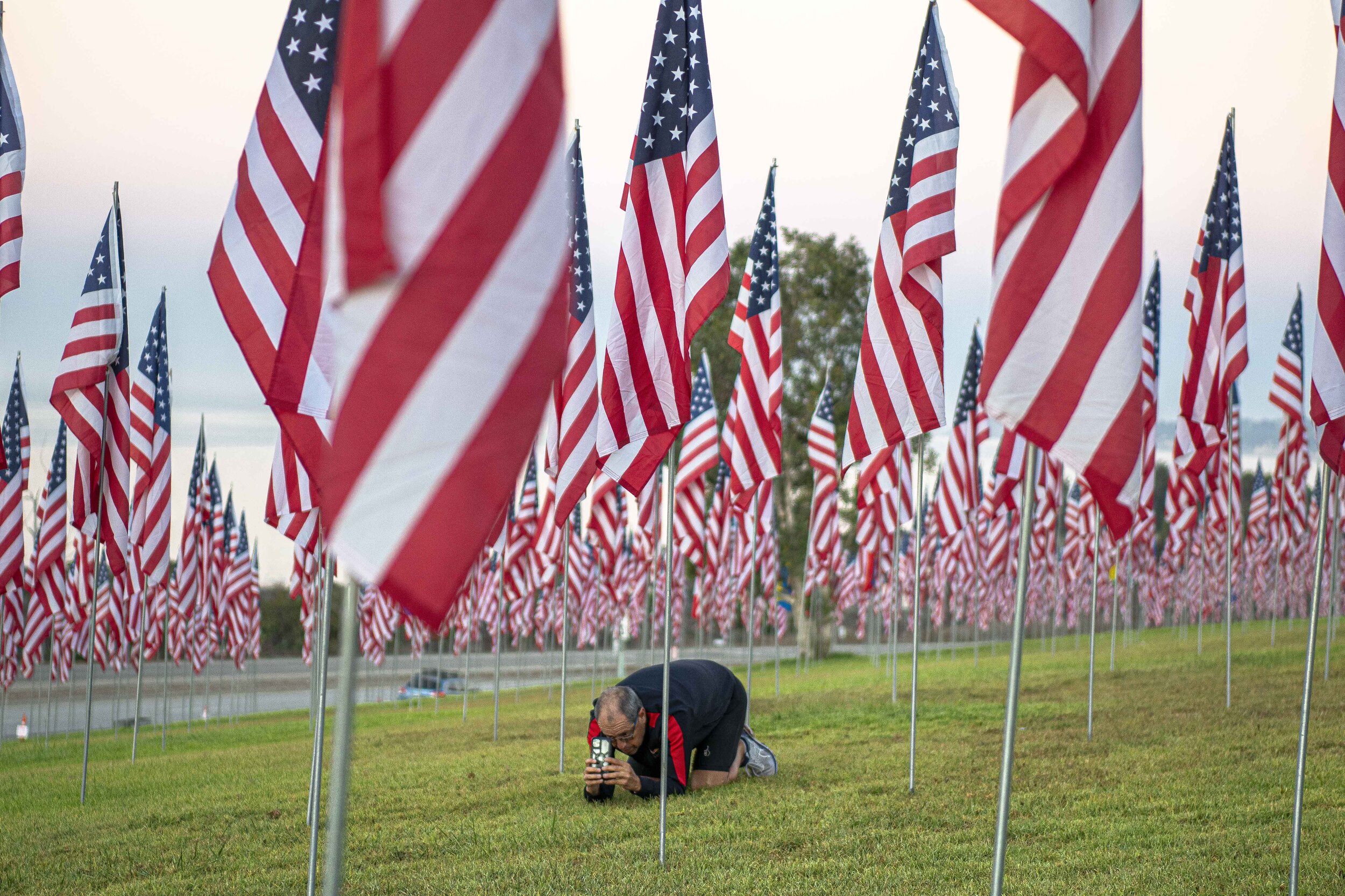  An onlooker takes a picture among the Waves of Flags diplay at Pepperdine University on September 11, 2021, in Malibu, Calif. (Jon Putman | The Corsair) 