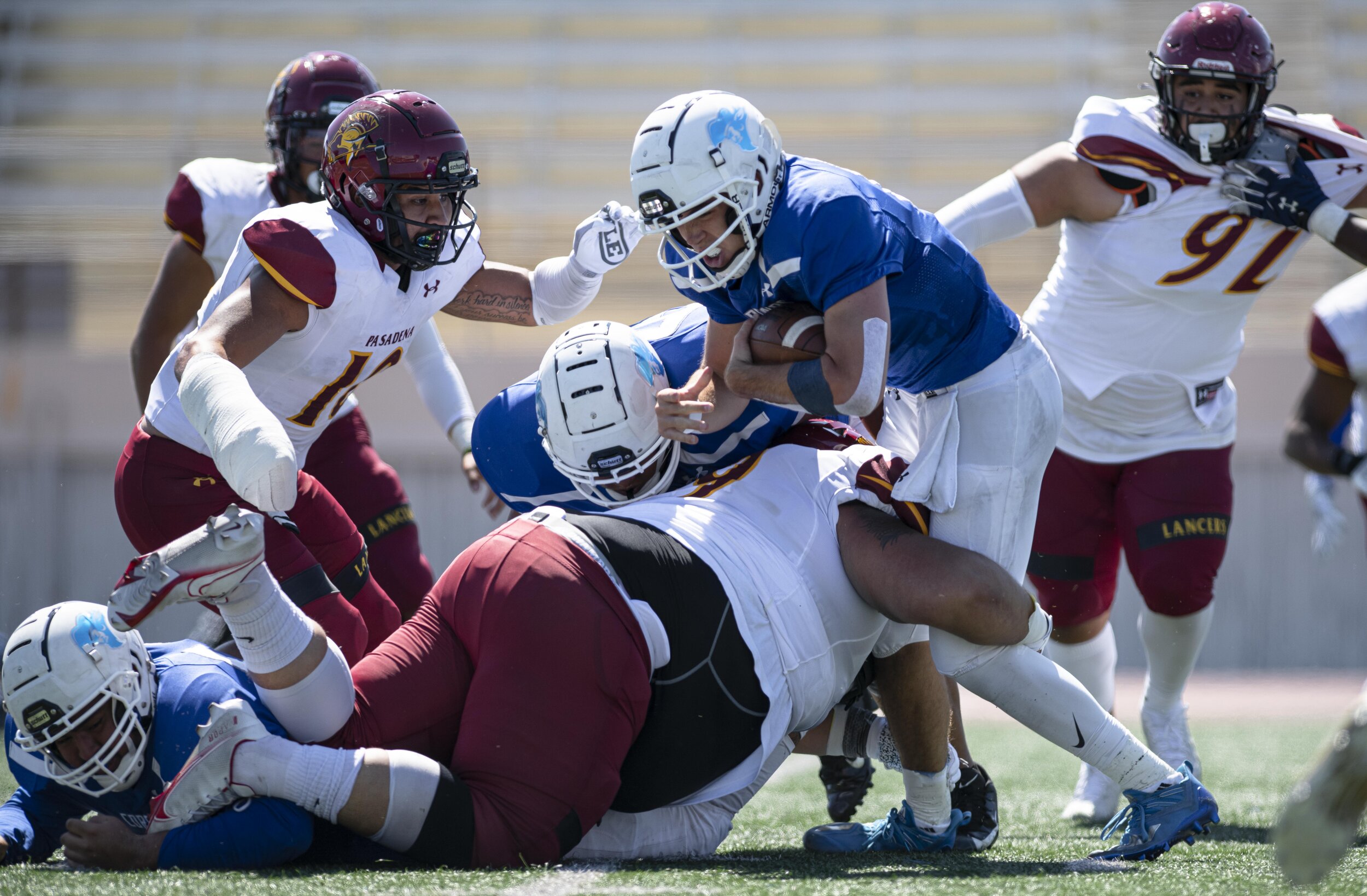  SMC freshman QB Sam Vaulton (14) pushes for every yard while being tackled by defenders. (Jon Putman | The Corsair) 