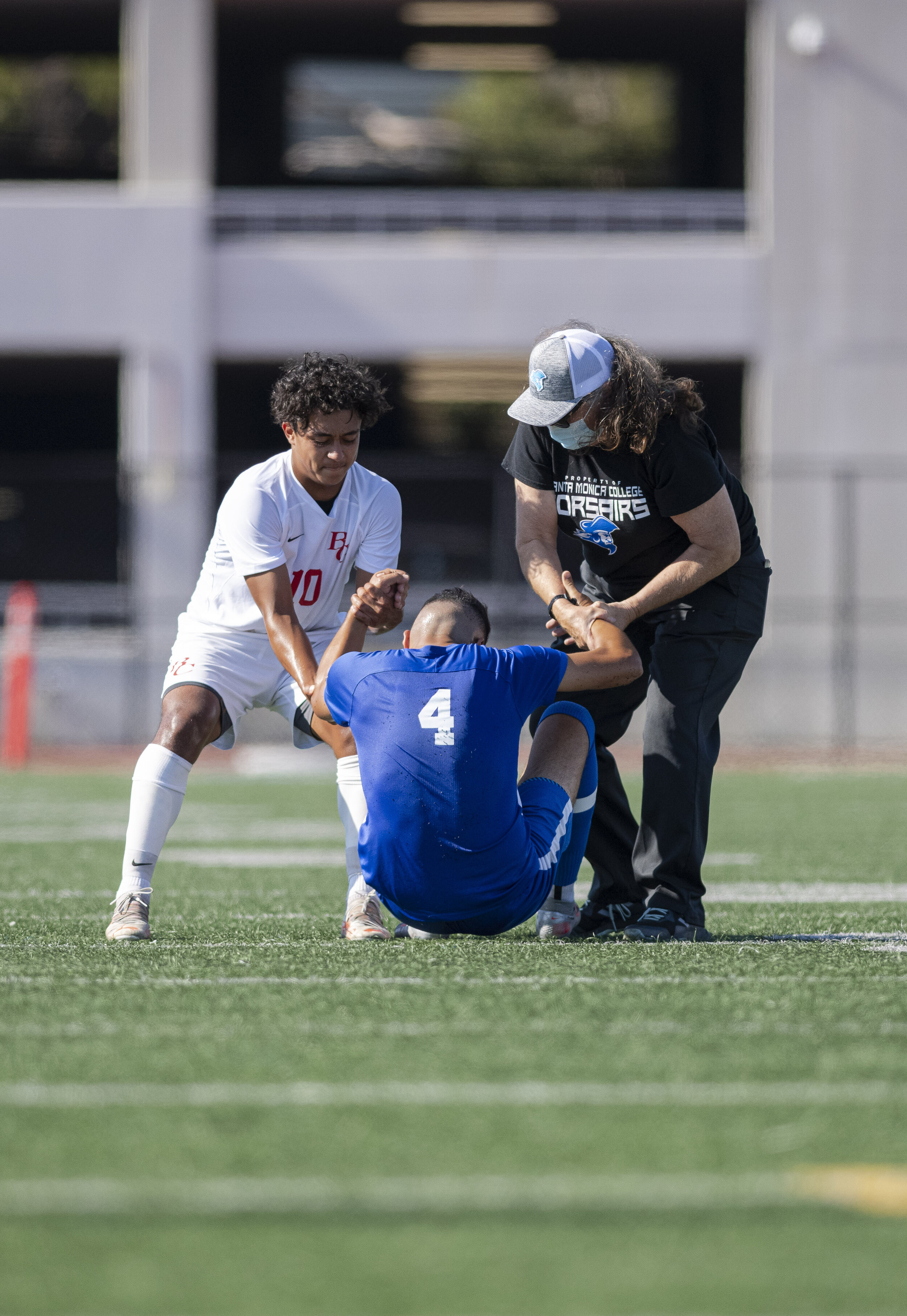  Santa Monica College Corsairs freshman Josh Rodriguez (4) gets helped up by the Bakersfield opponet that fouled him and the Santa Monica College Physical Therapist after a brutal collision. (Jon Putman | The Corsair) 