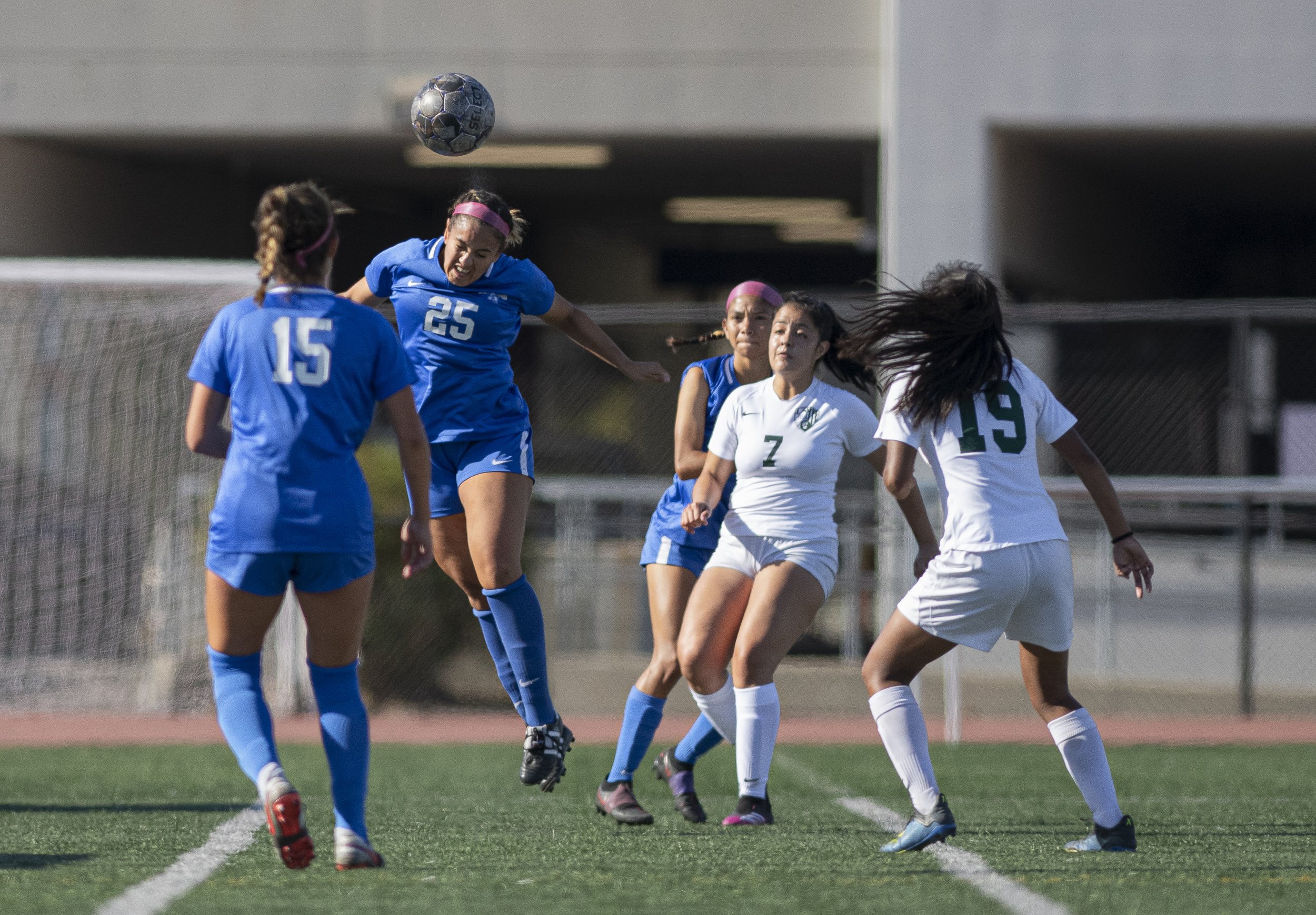  Santa Monica College Corsairs sophomore Cassie Velasquez (25)  heads the ball away from the Corsairs goal as teammates and LA Valley players surround her. (Jon Putman | The Corsair) 