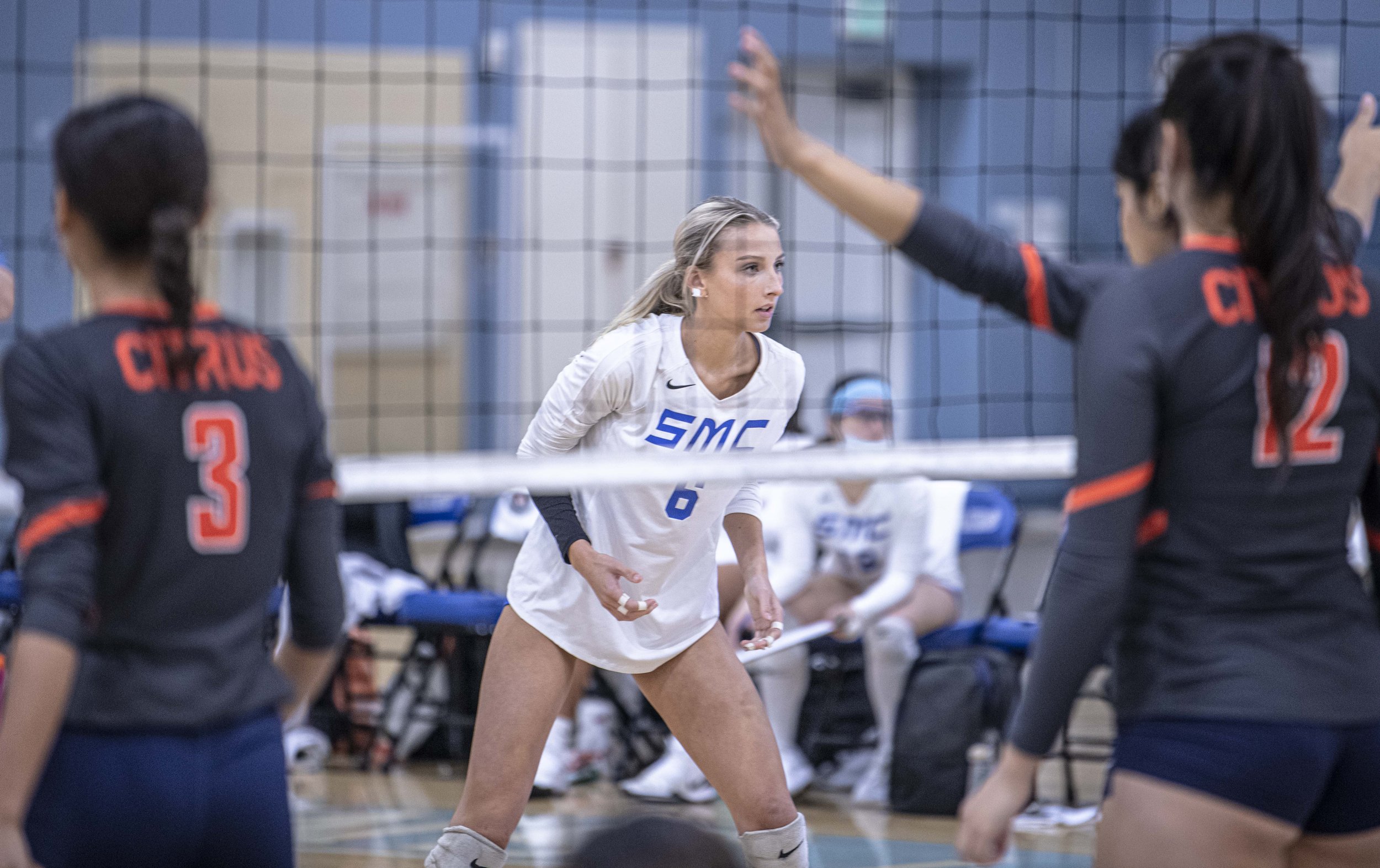  Santa Monica College Corsairs freshman Sophia Lawrance (6) stands ready for the serve with Citrus College players in frame. (Jon Putman | The Corsair) 