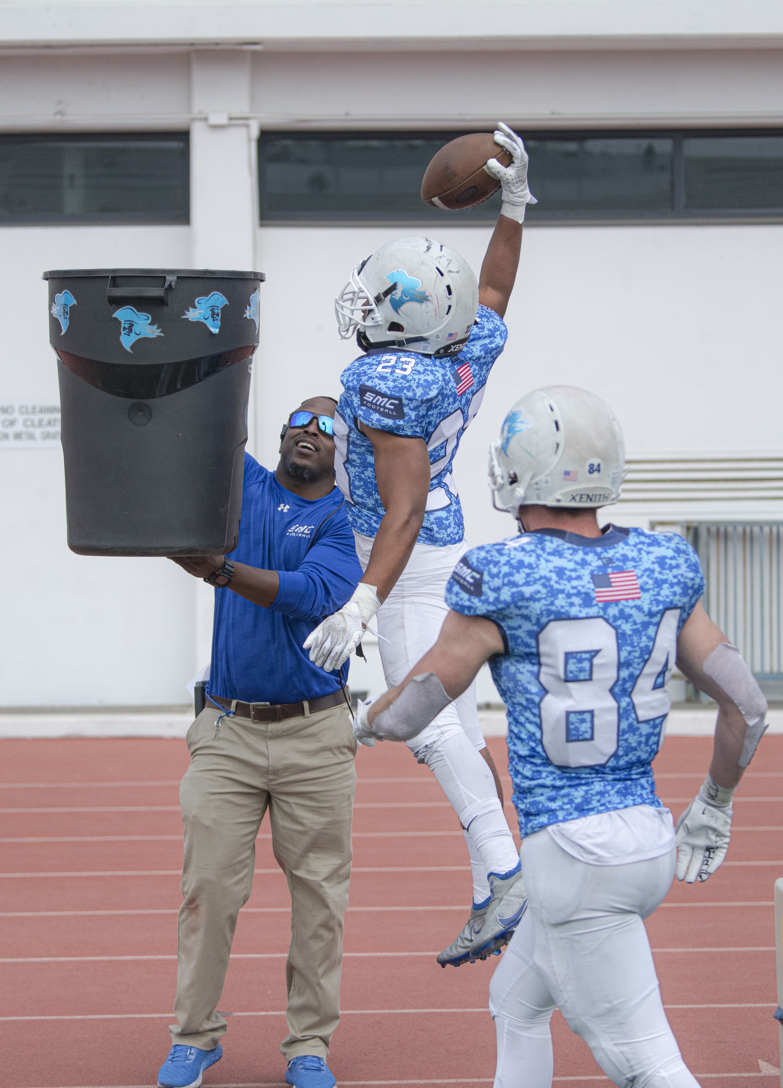  Santa Monica College Corsairs freshman DB Kayden Thomas (23) slams the ball in the trash can in celebration after making a crucial goal line interception for the Corsairs. (Jon Putman | The Corsair) 