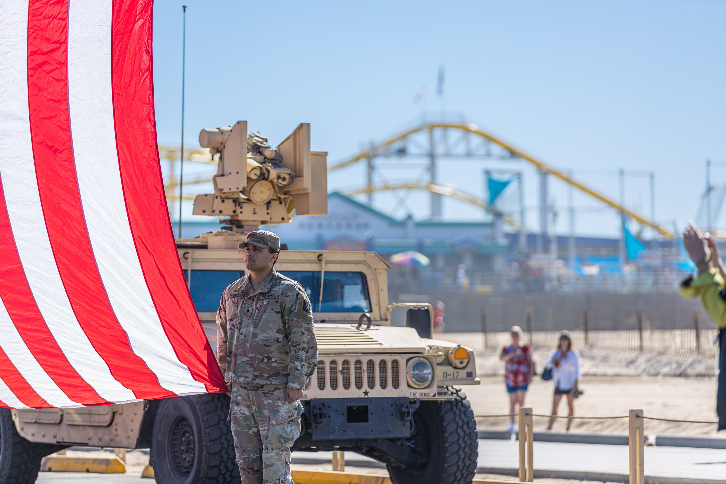  A member of the Army holds the American flag the Veterans Day commemoration near the Santa Monica Pier in Santa Monica, California on November 11, 2021. (Maxim Elramsisy | The Corsair) 