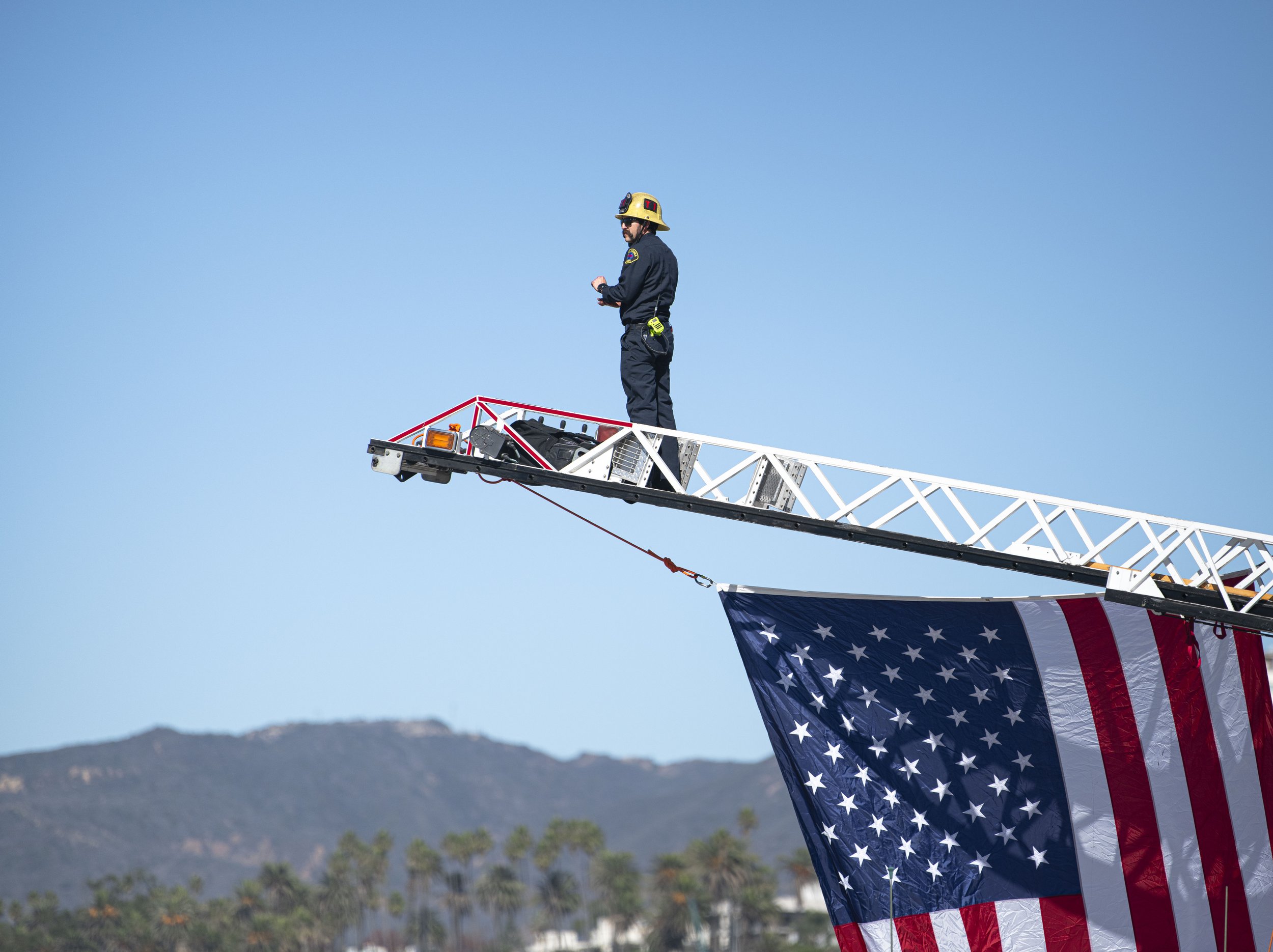  A Santa Monica Firefighter stands atop the fire ladder and looks at the ocean views after securing the enlarged American Flag for the Veterans Day event hosted by both the Los Angeles Army Recruitment Battalion and the California Army National Gaurd