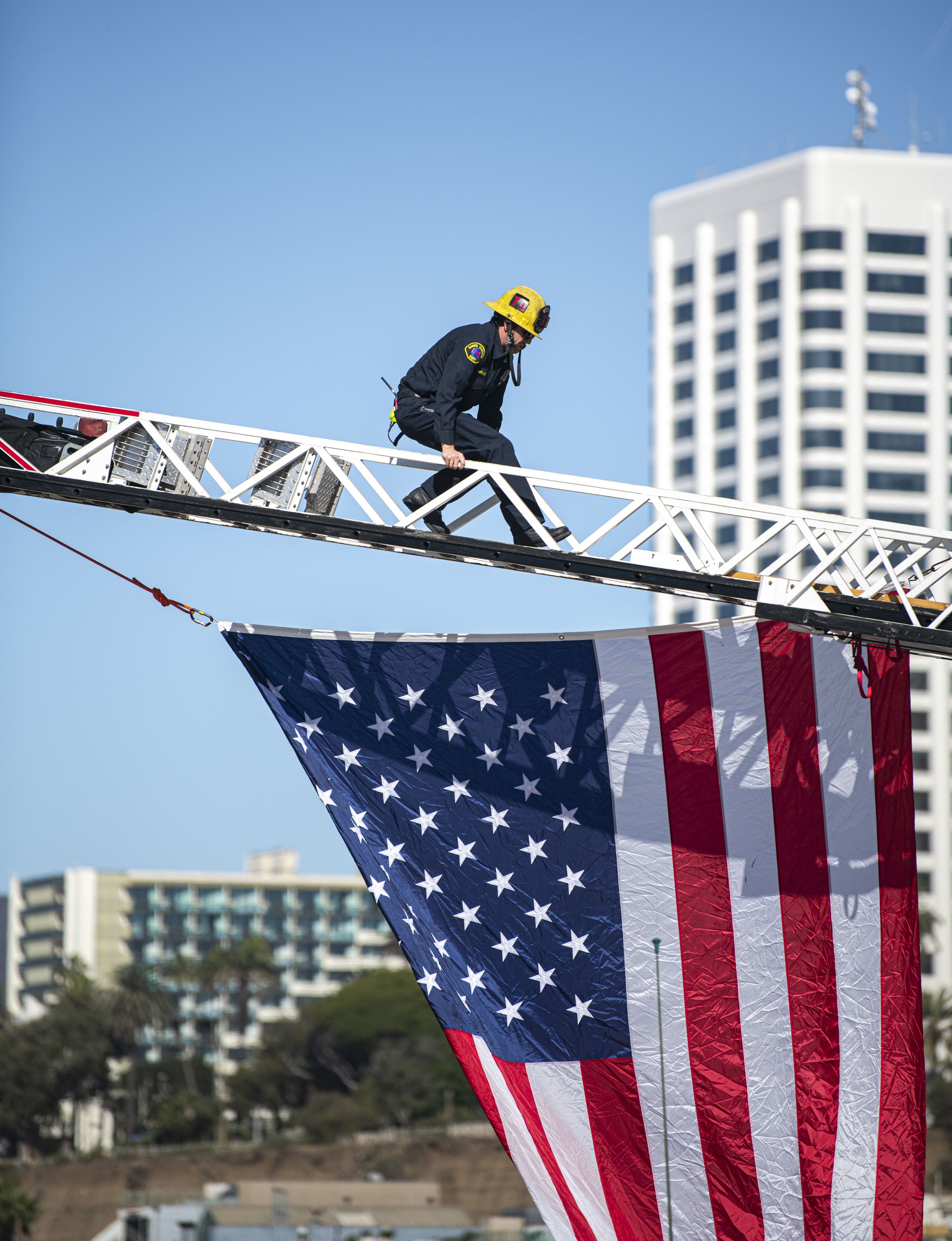 A Santa Monica Firefighter runs down the fire ladder on the firetruck after assemble the enlarged American flag for the Veterans Day event hosted by both the Los Angeles Army Recruitment Battalion and the California Army National Gaurd on Nov. 11, 2
