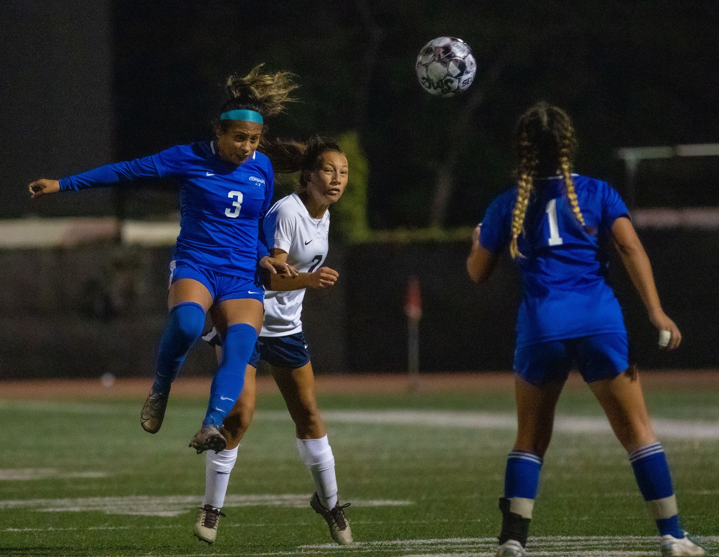  #3, Monica Moya jumping into defender to headbutt the ball 