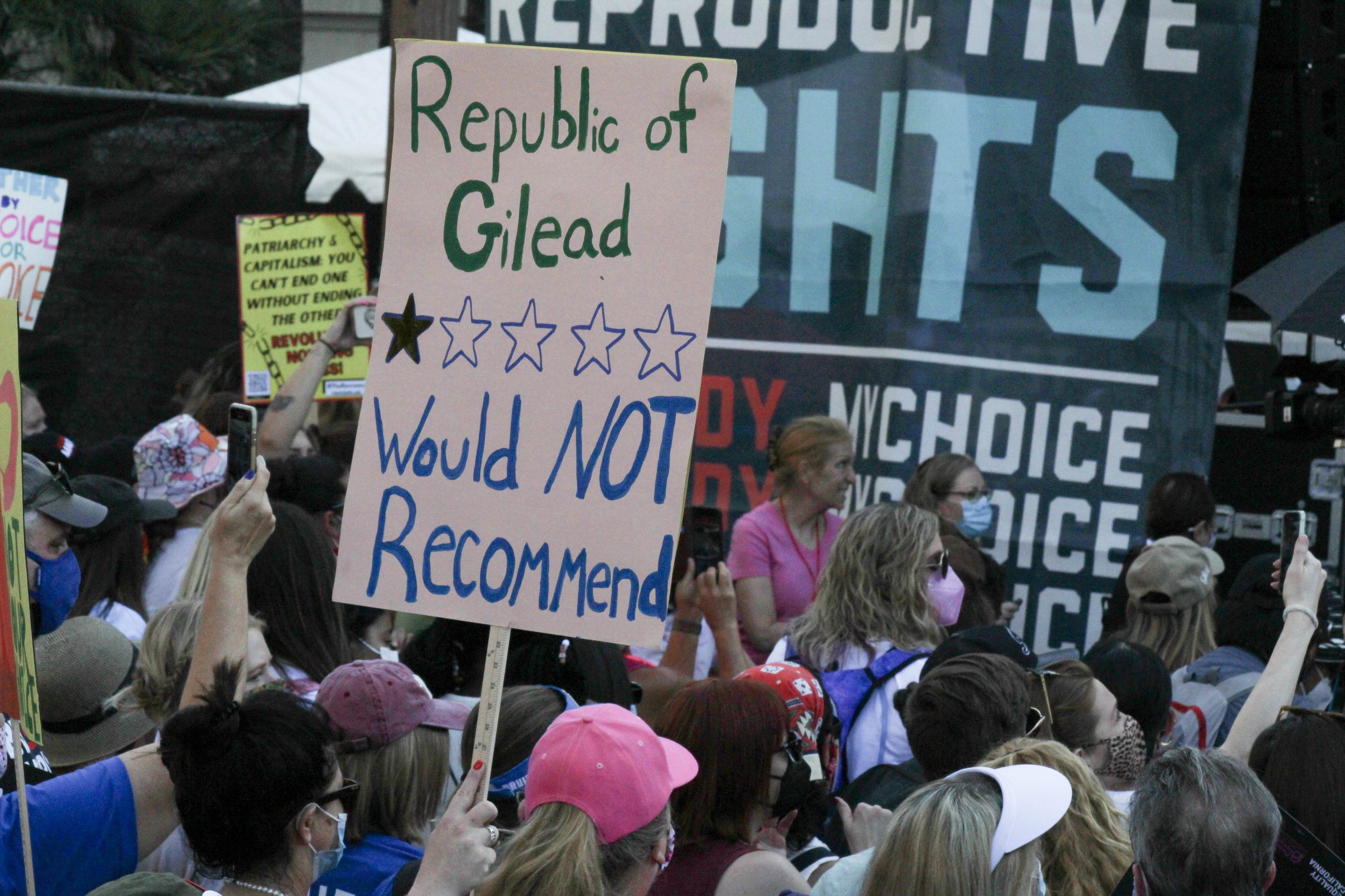  Protestor with sign reading "Republic of Gilead - would not recommend," stands among other protestors attending the Women's March in Downtown Los Angeles, CA. October 02, 2021. (Roxana Blacksea | The Corsair) 