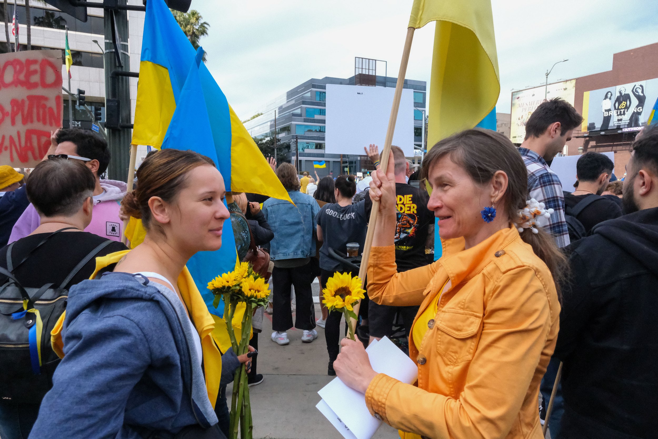  Two anti war protesters hold sunflowers and Ukranian flags as they discuss with one another, at the Rally to Stand with Ukraine in Westwood, Los Angeles, California on Saturday, February 26, 2022 (Anna Sophia Moltke | Corsair) 