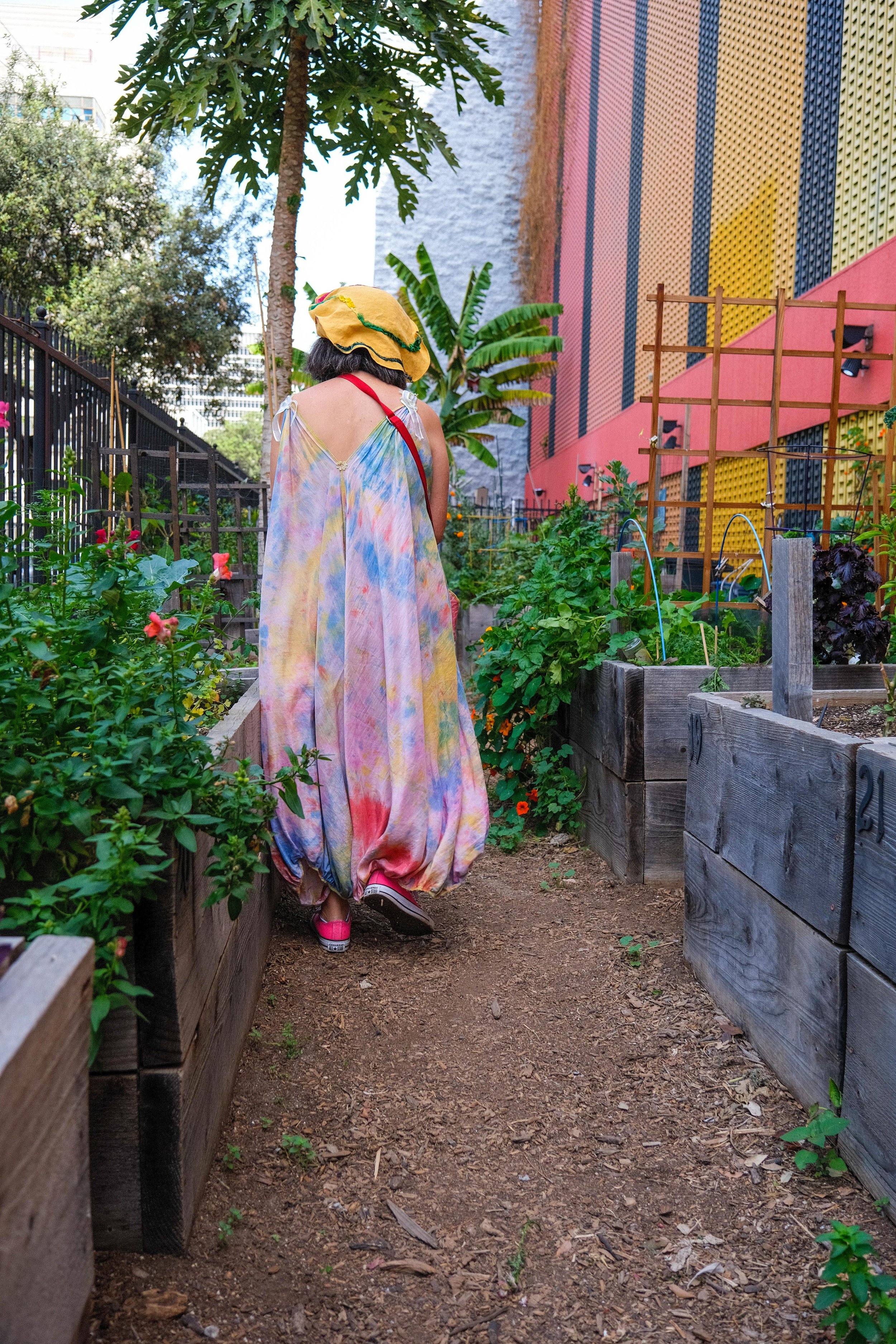  Rain Boe Wave walks through the garden, in her handmade tie-dye jumpsuit at the Spring Street Community Garden in Downtown Los Angeles on Monday, March 21, 2022. (Anna Sophia Moltke | The Corsair) 