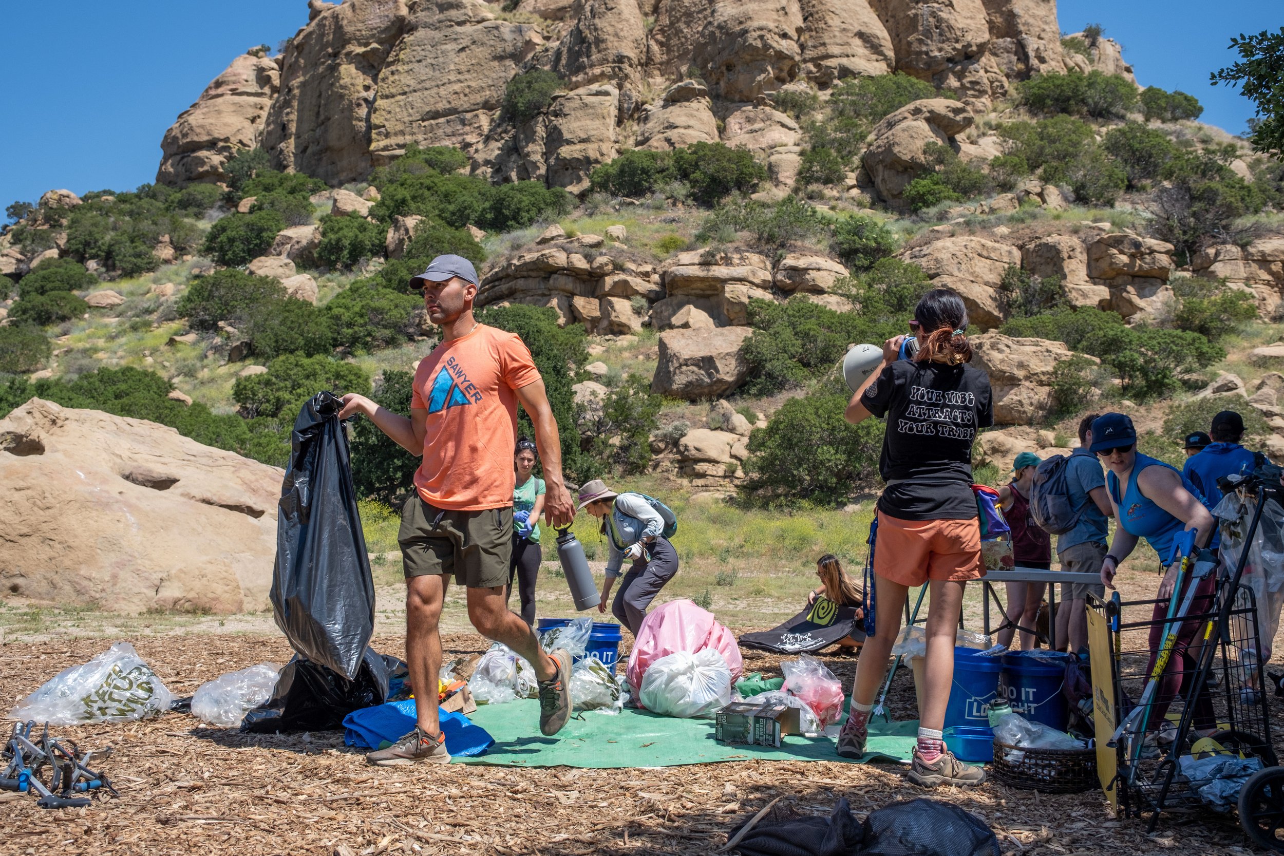  Attendees carry the bags up to the sign, where Waste Management has been ordered to pick up the collection of trash. Stoney Point Park in Chatsworth, Los Angeles, California on Saturday, April 9, 2022. (Anna Sophia Moltke | The Corsair) 