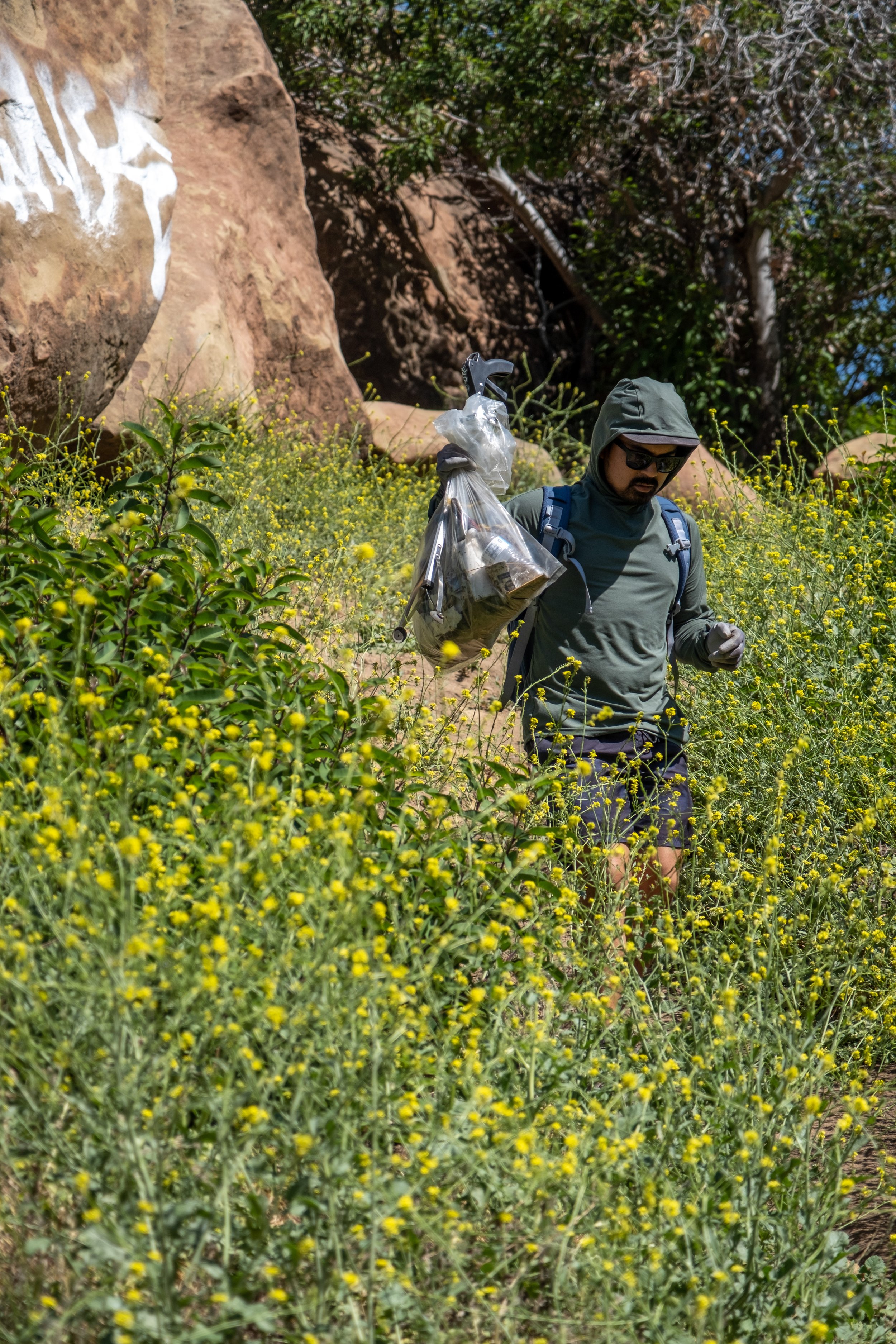  Josh Quitiquit (cq) walks down a trail, carrying a bag full of trash at Stoney Point Park in Chatsworth, Los Angeles, California on Saturday, April 9, 2022. (Anna Sophia Moltke | The Corsair) 