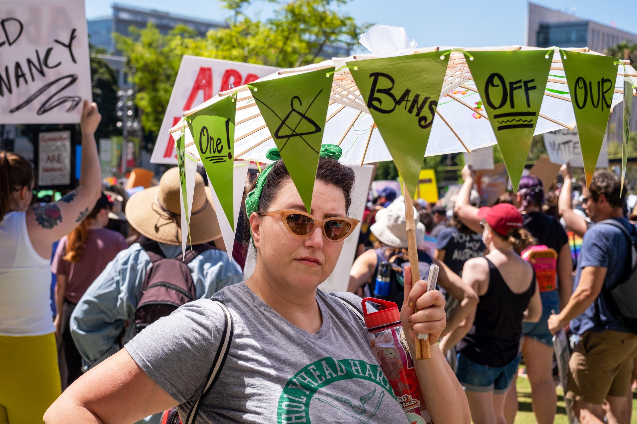  Mandy Arnold holds an umbrella with triangular green signs hanging from it. Bans Off Our Bodies Rally at City Hall in downtown Los Angeles on Saturday, May 14, 2022. (Anna Sophia Moltke | The Corsair) 