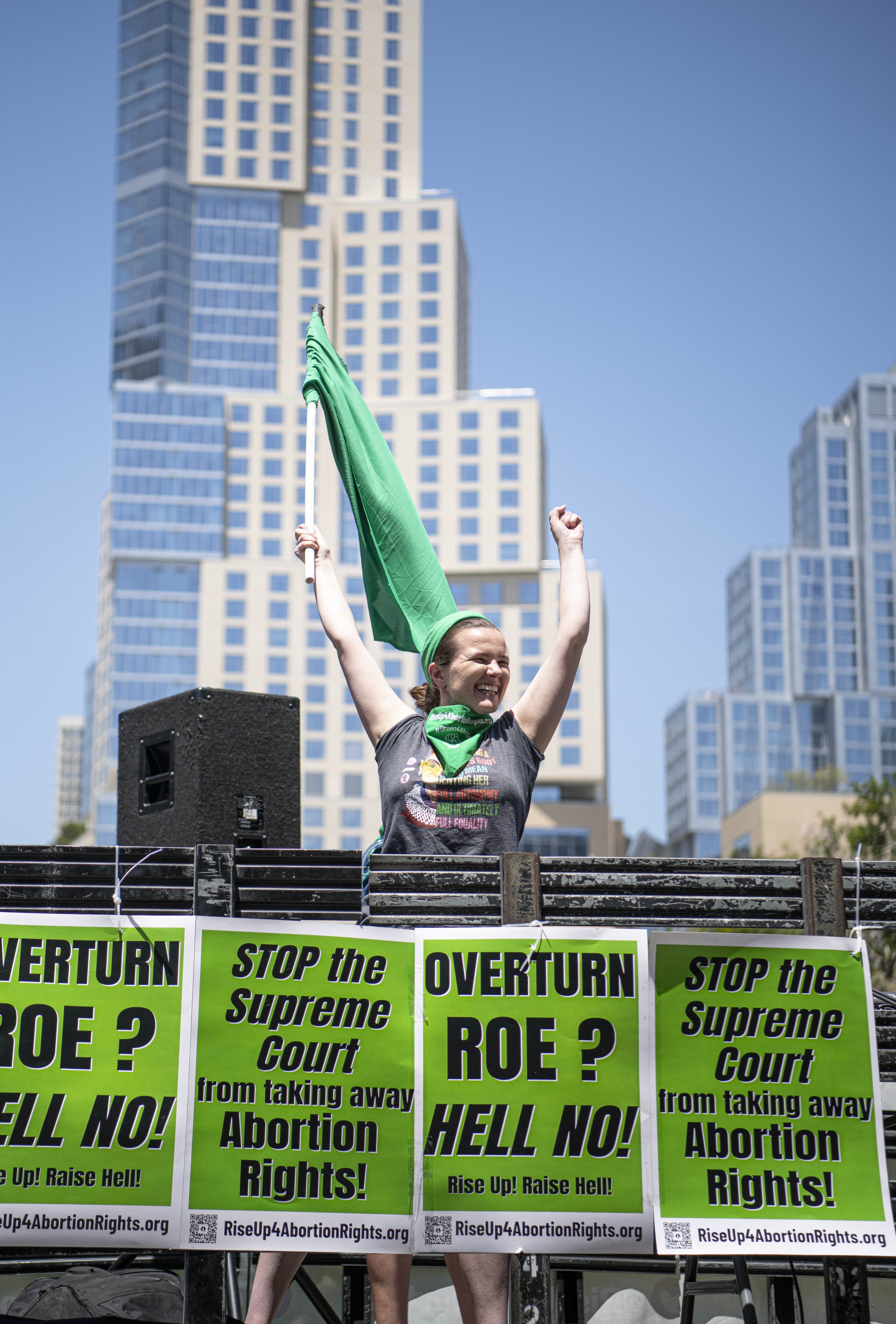  A Rise4AbortionRights leader waves a green flag to the masses as they march through the streets of DTLA on May 14, 2022 in Los Angeles, CA. (Jon Putman | The Corsair) 