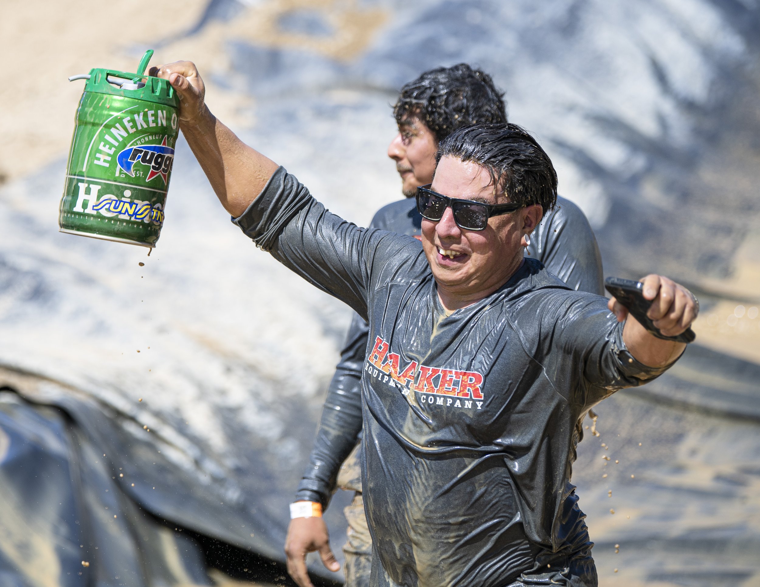  Bo Velasco from the HAAKER equipment group celebrates with his Heineken mini keg that he carried throughout the entirety of course, after successfully making it through the mud slide pit unscathed on April 9, 2022. (Jon Putman | The Corsair) 
